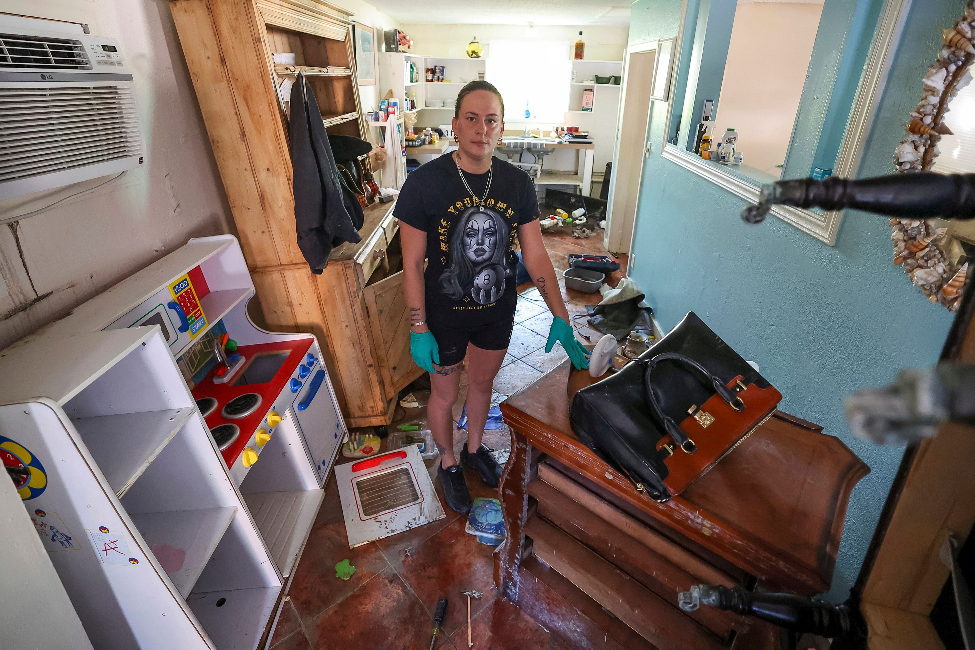 Amanda Normand cleans up the home of Aiden Bowles who died in the home during flooding from Hurricane Helene on Wednesday, Oct. 2, 2024, in Indian Rocks Beach, Fla. (AP Photo/Mike Carlson)