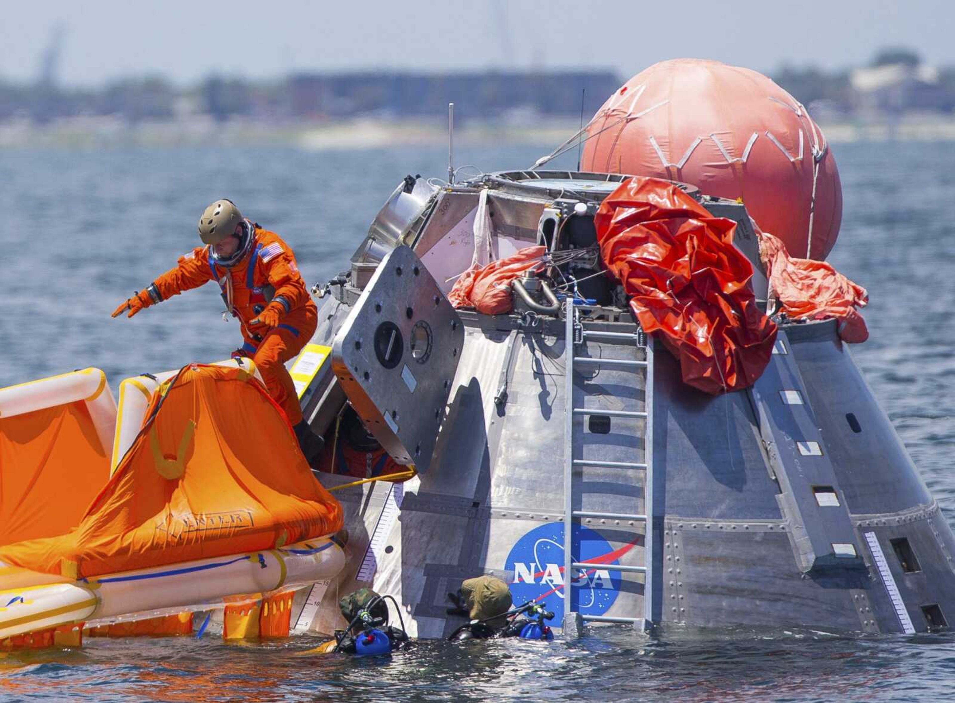 NASA astronaut Mike Fincke jumps into a life raft from an Orion capsule the astronauts are using for a recovery test July 13, 2017, about 4 miles off of Galveston Island, Texas, in the Gulf of Mexico, the first time since the Apollo program NASA has practiced such egress techniques from a capsule in open water.