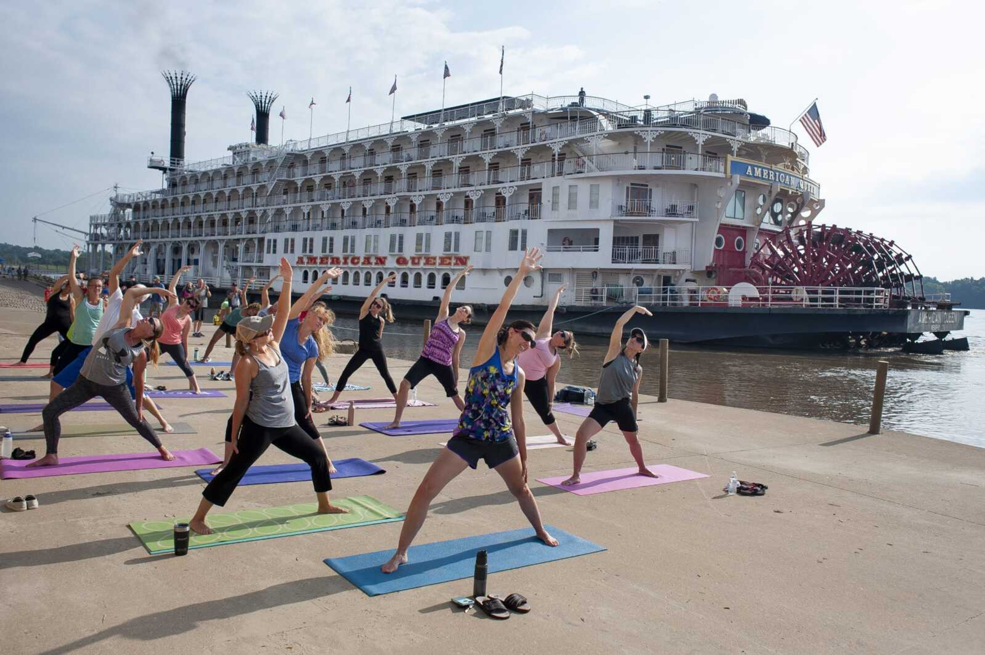 Front three classmates from left: Robin Harbison of Cape Girardeau, Colette Banda of Jackson and Cristina Welker of Jackson take part in a riverfront yoga class while American Queen is docked Saturday along the Mississippi River in Cape Girardeau.