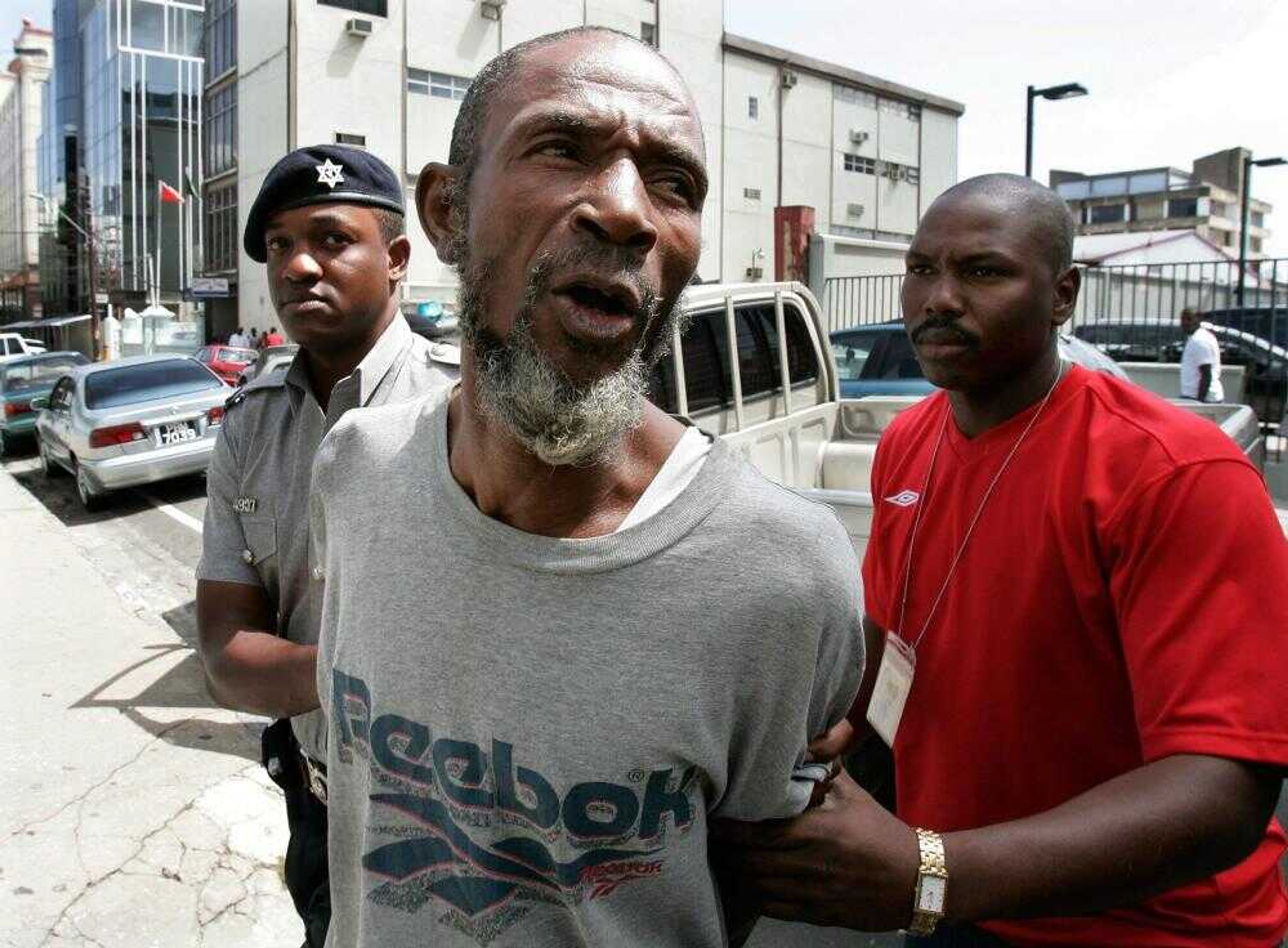 Trinidad police officers to the Magistrate's Court escorted Abdel Nur on Tuesday in Port-of-Spain, Trinidad. Nur, the fourth suspect in an alleged plot to bomb a fuel pipeline feeding New York's John F. Kennedy International Airport, turned himself in at a police station outside the Trinidadian capital. (Andres Leighton ~ Associated Press)