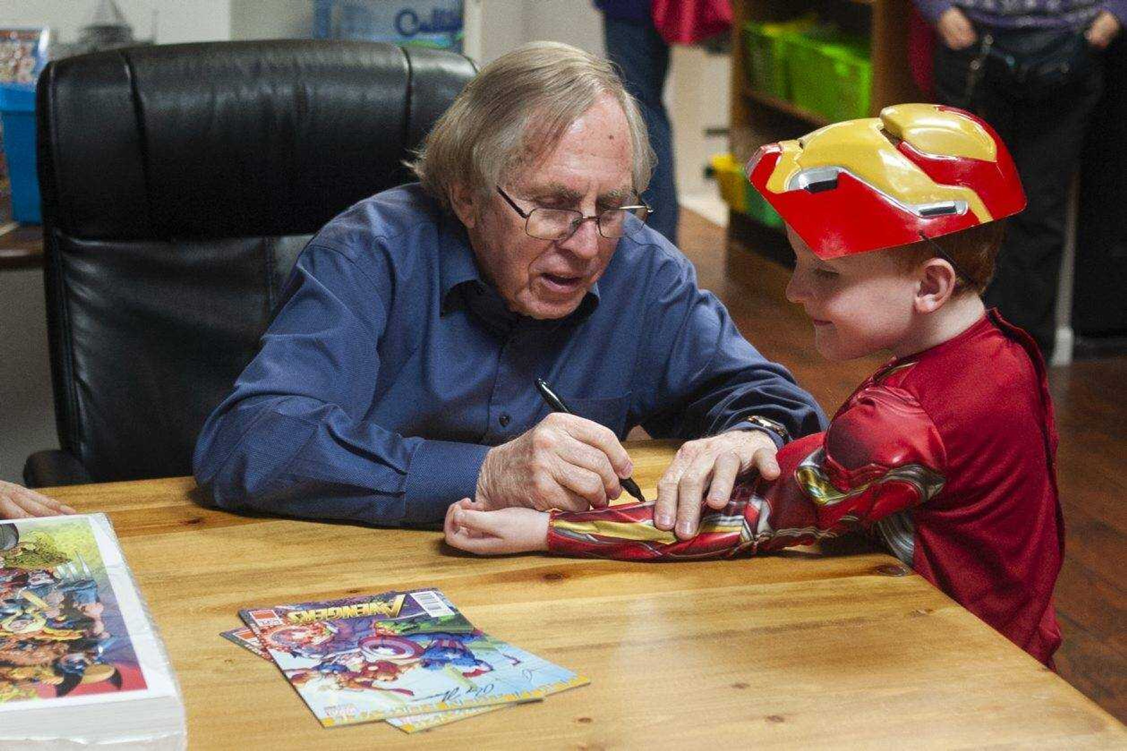 Former editor-in-chief of Marvel Comics and Jackson native Roy Thomas signs the Iron Man costume of Tristen Watkins, 5, of Marble Hill, Missouri, on Saturday at the Cape Girardeau County History Center in Jackson. Thomas is the co-creator of the superhero Wolverine and succeeded the late Stan Lee as editor-in-chief at Marvel.