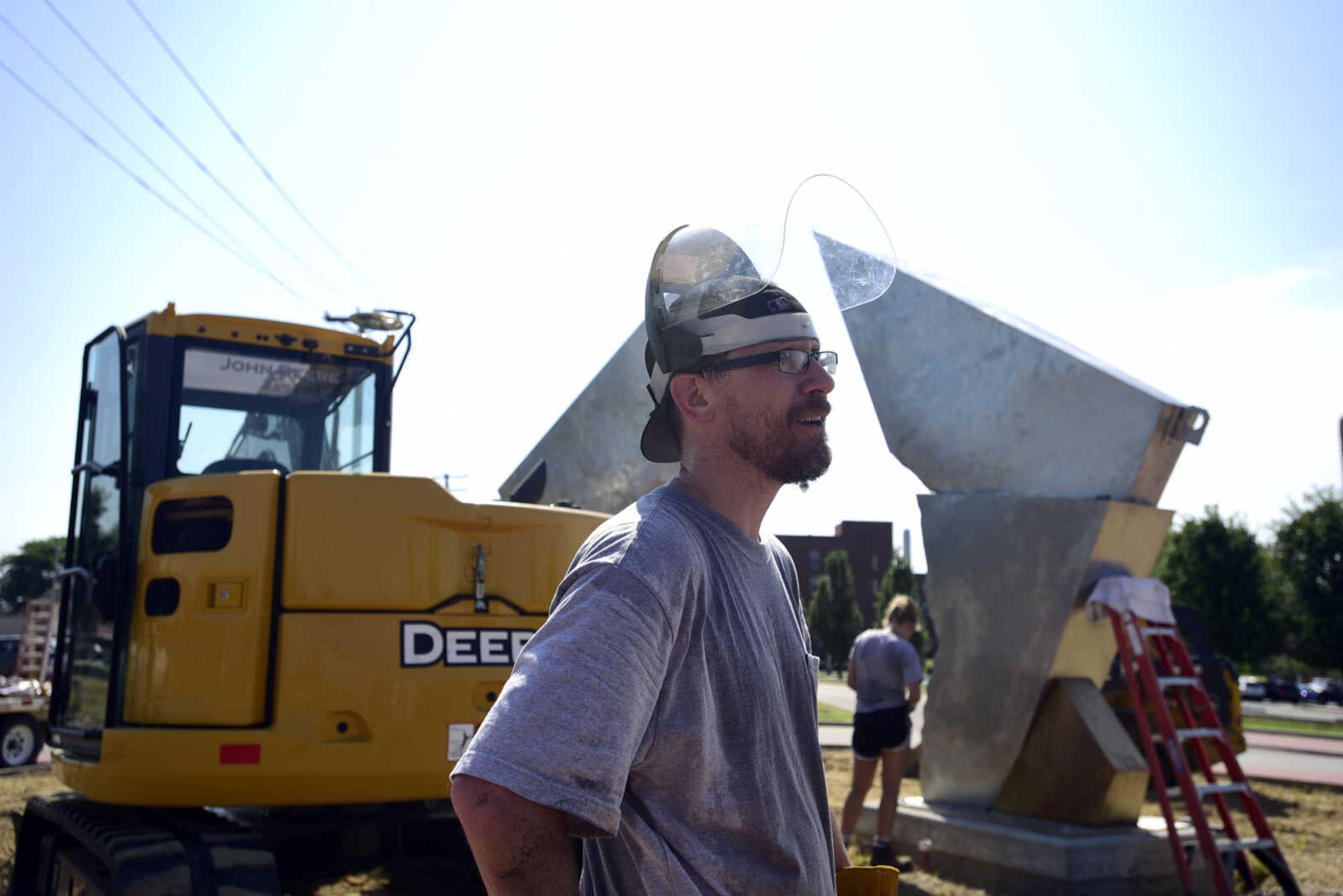 Chris Wubbena stands in the Fountain Street roundabout after the installation of his sculpture, "Commence" on Monday, July 24, 2017, near the River Campus in Cape Girardeau.