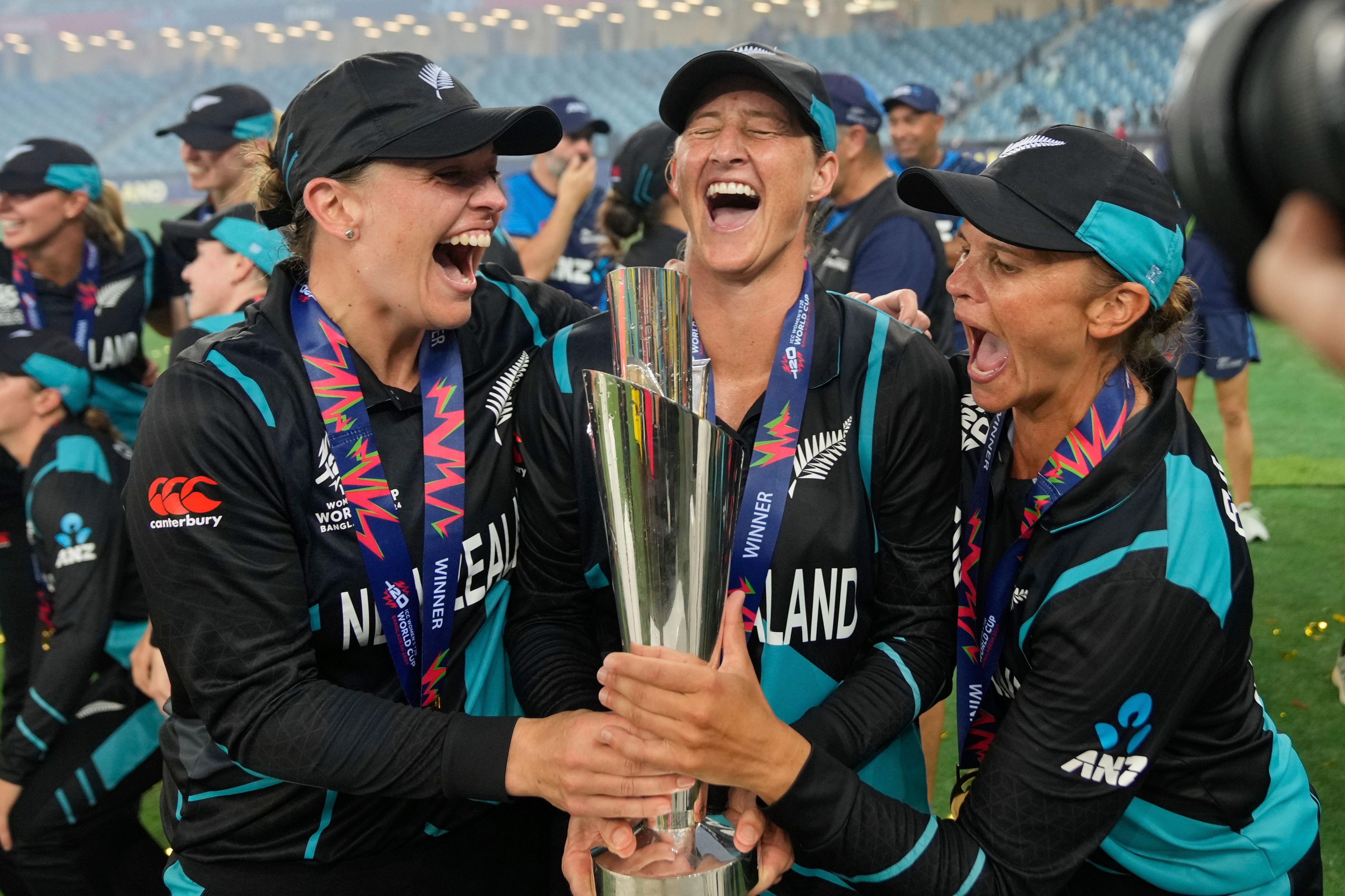 New Zealand's captain Sophie Devine, center, poses with teammates Lea Tahuhu, left, and Suzie Bates with the trophy after winning the ICC Women's T20 World Cup 2024 final match against South Africa at Dubai International Cricket Stadium, United Arab Emirates, Sunday, Oct. 20, 2024. (AP Photo/Altaf Qadri)