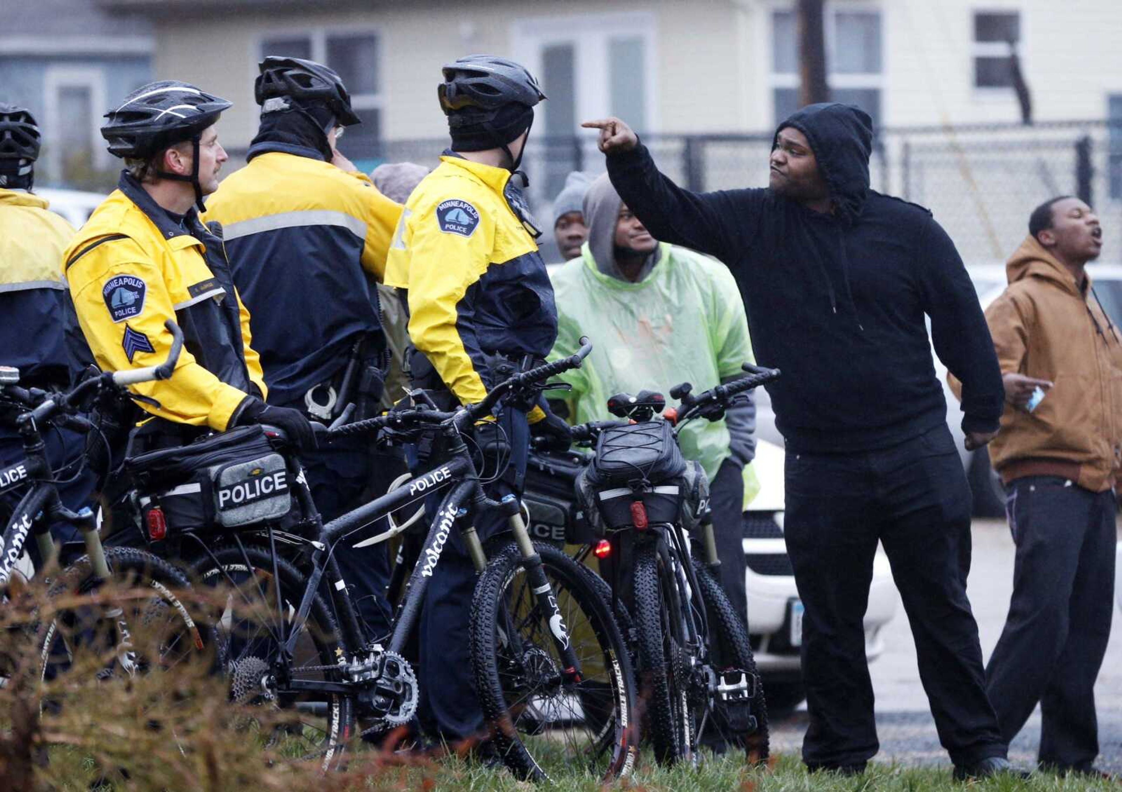 A protester has some words with Minneapolis police officers on bikes as a Black Lives Matter protest continued Wednesday at the Minneapolis Police Department's 4th Precinct in Minneapolis. It was the fourth day of protests of the killing of 24-year-old Jamar Clark, an unarmed black man, by a Minneapolis police officer. (Jim Mone ~ Associated Press)