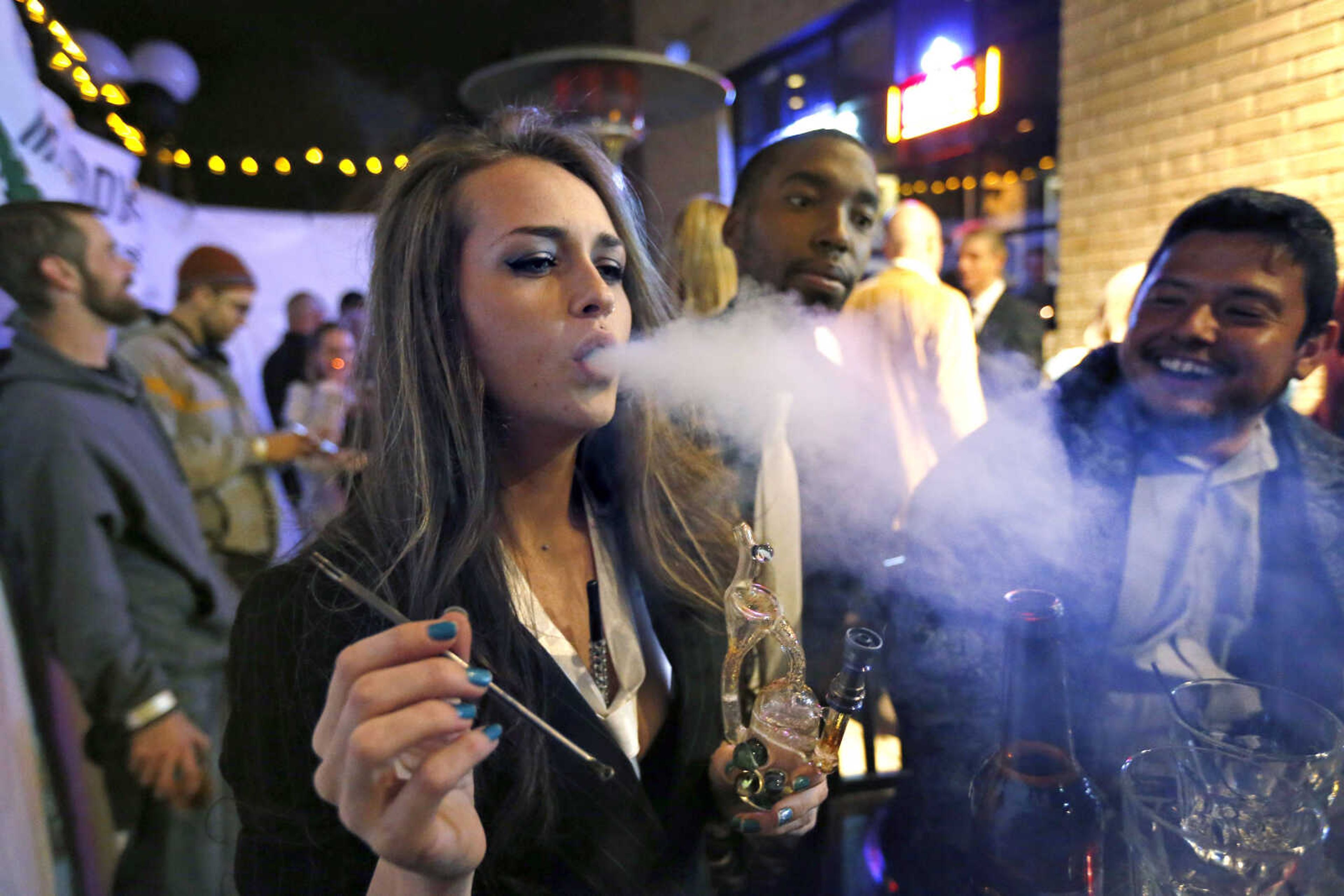 Partygoers smoke marijuana during a Prohibition-era themed New Year's Eve party Dec. 31, 2013, at a bar in Denver, celebrating the start of retail pot sales.