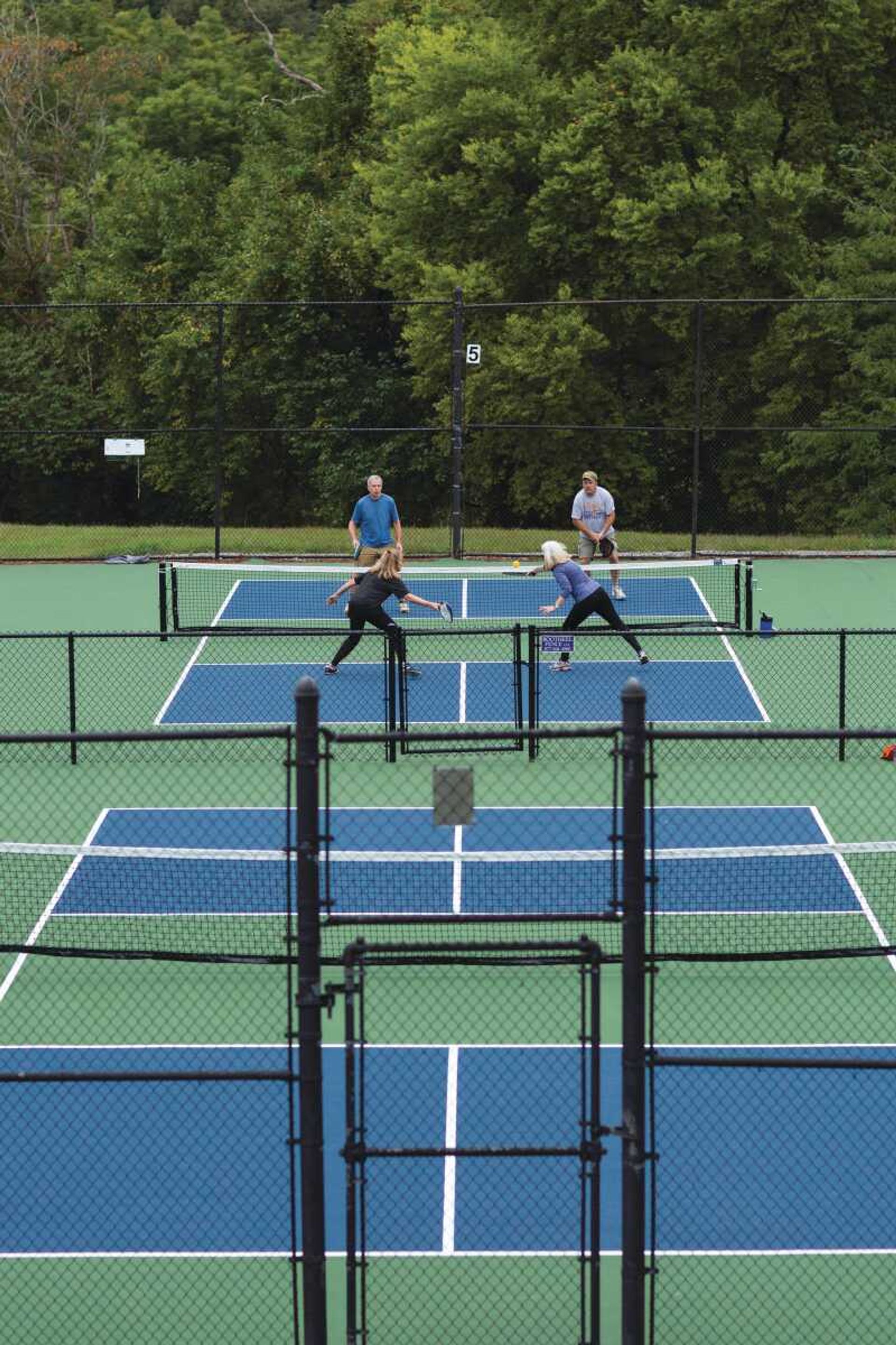 Players compete in a game of doubles pickleball at the Cape Girardeau Country Club. The club replaced its two tennis courts with six smaller pickleball courts.