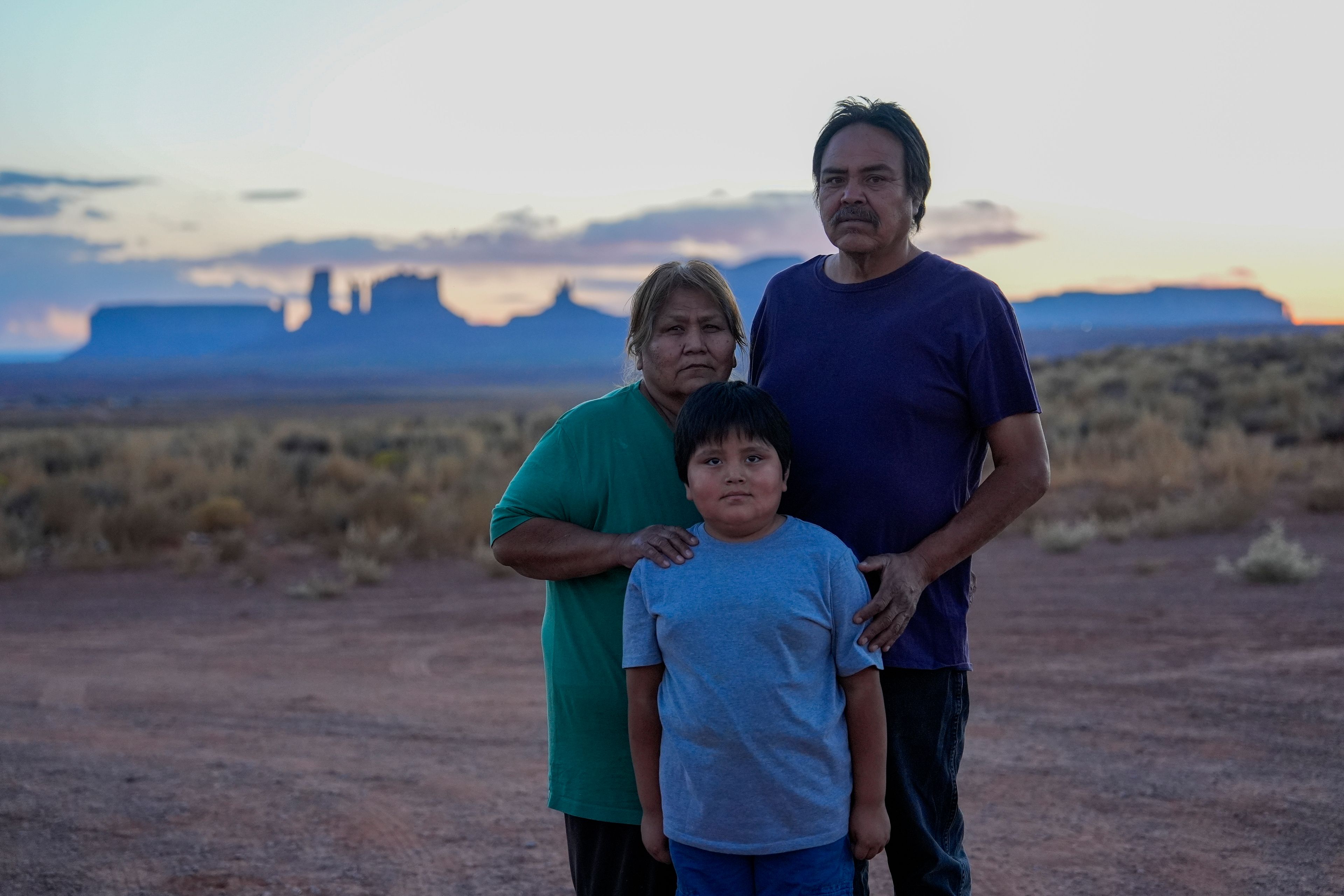 Lorraine Black, left and Ricky Gillis, right, pose for a portrait with their grandson, Liam Gillis, 7, outside their home, Wednesday, Oct. 9, 2024, on the Navajo Nation in Halchita, Utah. (AP Photo/Joshua A. Bickel)