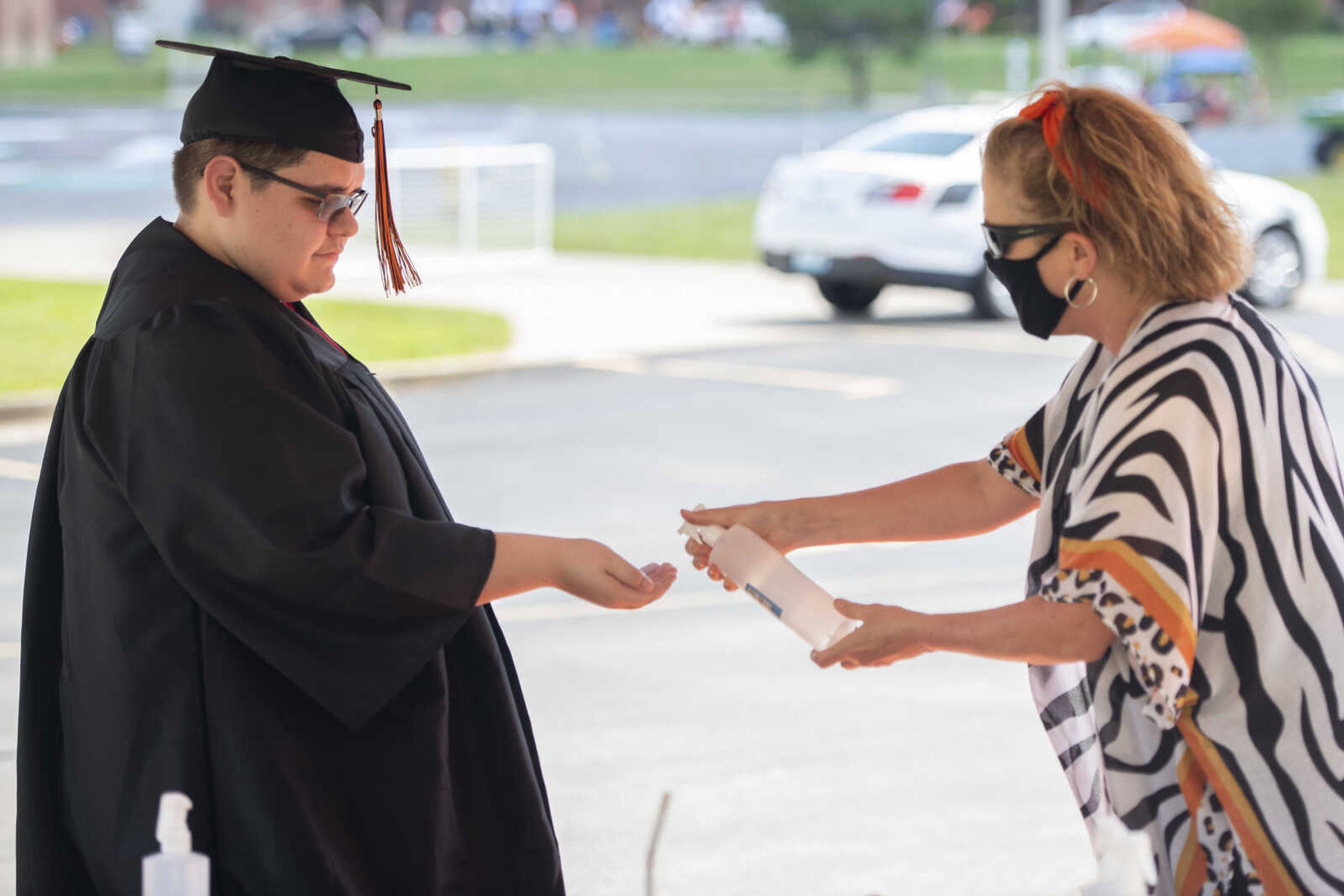 Graduate Christian Cruz Marcial receives hand sanitizer from Katy Andersson during a drive-through graduation ceremony Saturday, June 13, 2020, at Cape Girardeau Central High School in Cape Girardeau.&nbsp;