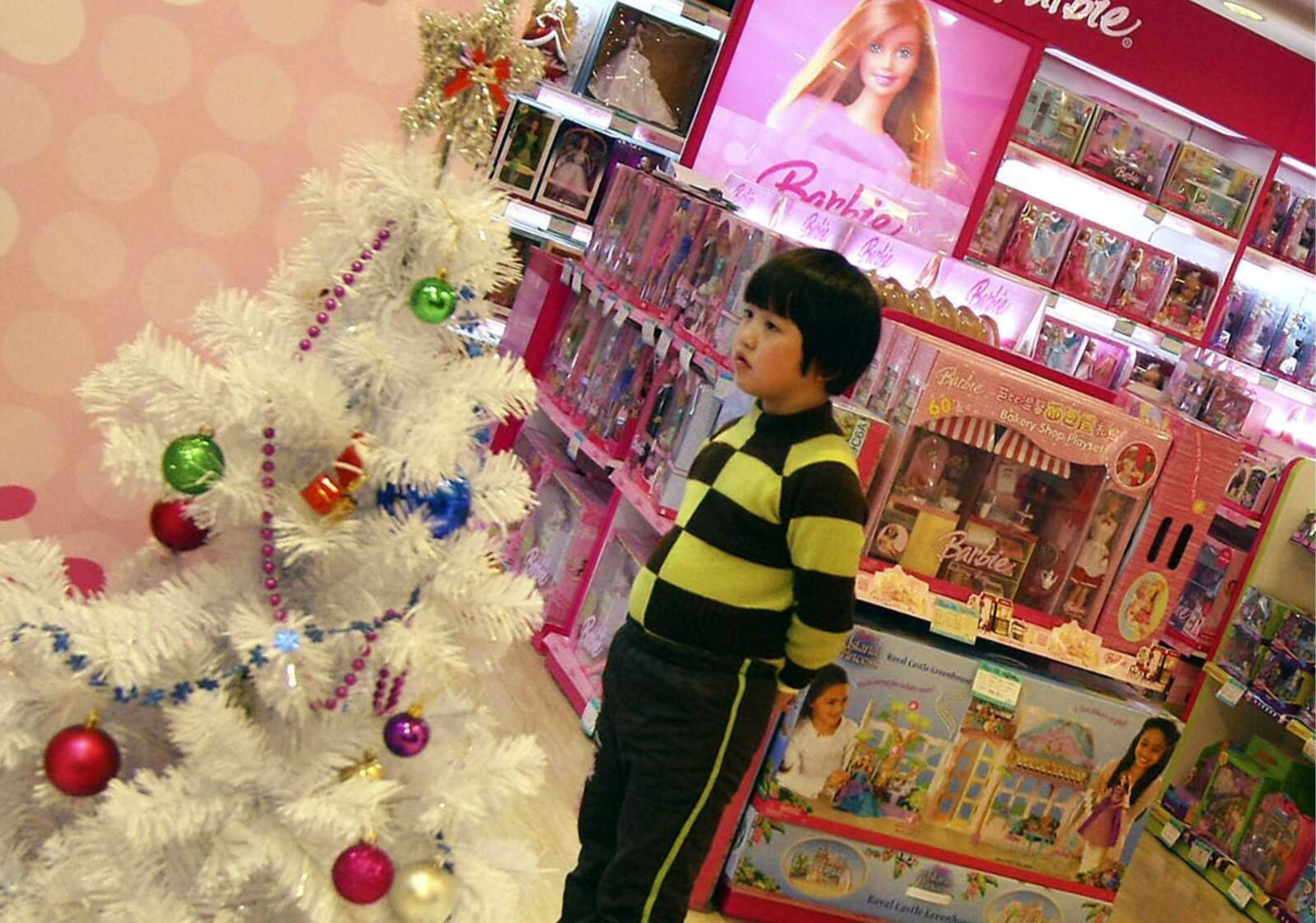 A young girl looked at Barbie dolls at a department store Sunday in Shanghai, China. Chinese families that can afford to tend to buy well-known, better quality foreign brands. (Associated Press)