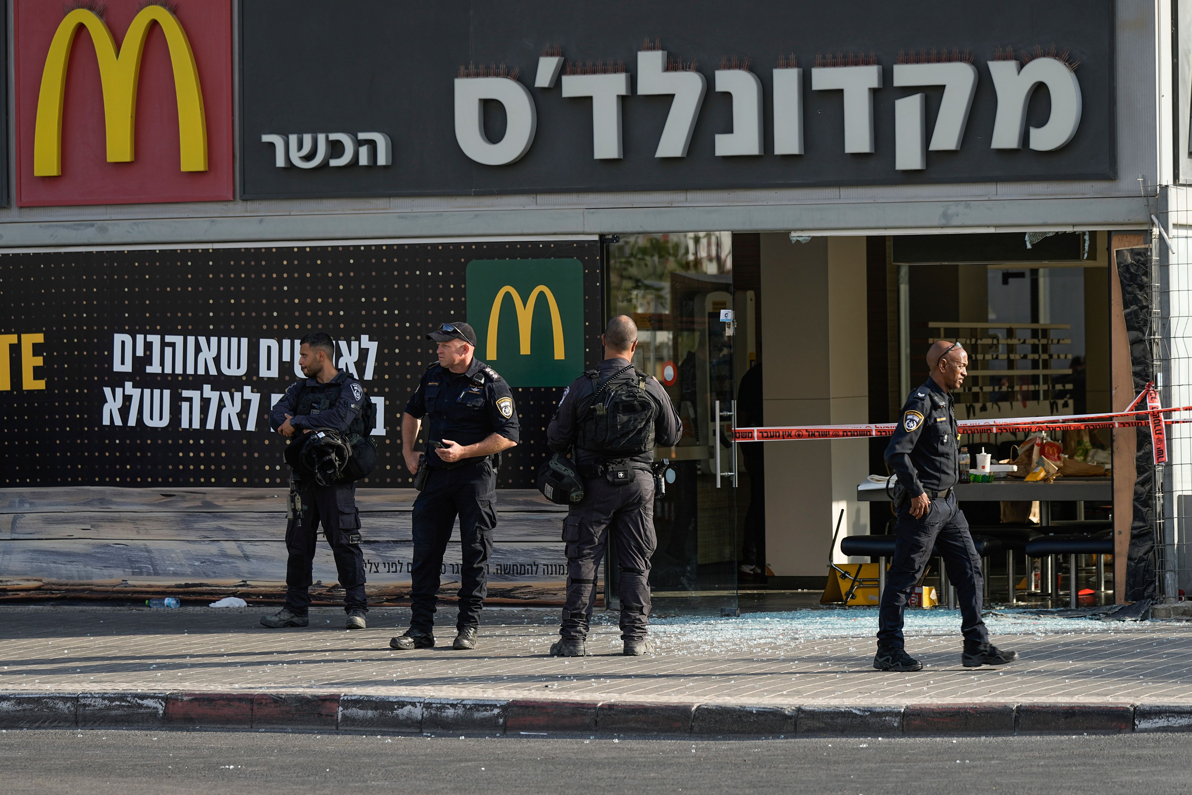 Police officers examine the scene of a stabbing and shooting attack where Israel's Magen David Adom rescue service said one person was killed and several others were wounded in Beersheba, Israel, Sunday, Oct. 6, 2024. (AP Photo/Tsafrir Abayov)