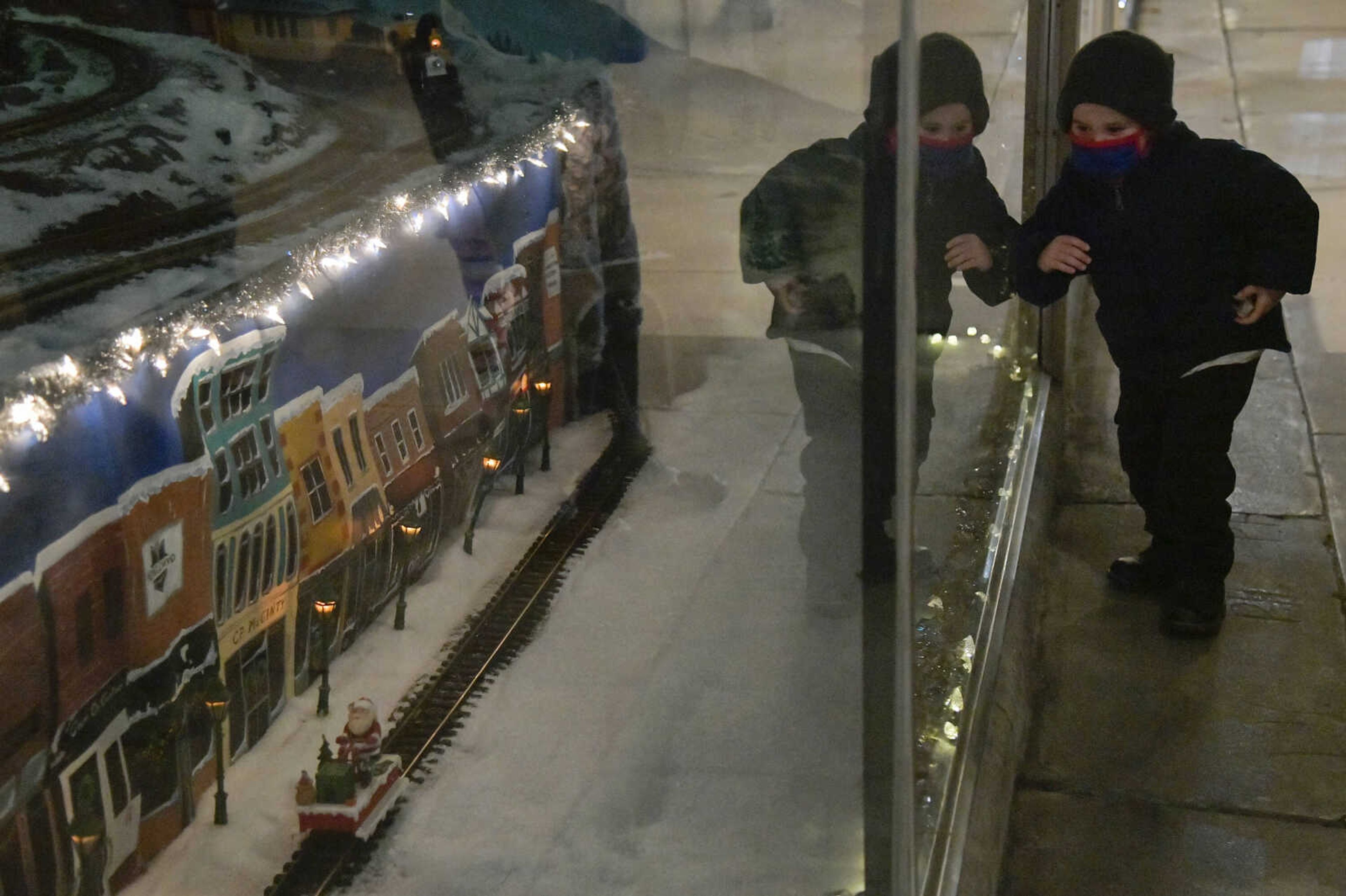 Zade Underwood, 4, chases a train in the window display at Hutson's Furiture Company during the Downtown Christmas Open House in Cape Girardeau on Friday, Dec. 4, 2020.