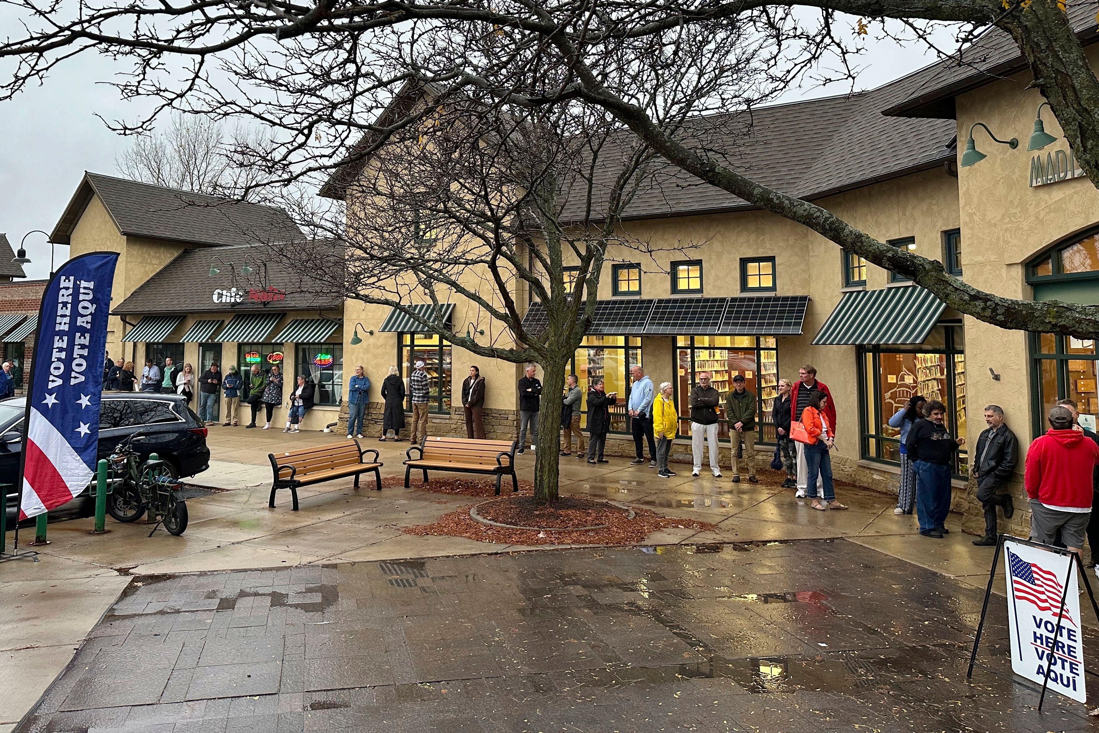 People line up in the rain waiting for polls to open to vote on Election Day, on Tuesday, Nov. 5, 2024, in Madison, Wis. (AP Photo/Scott Bauer)