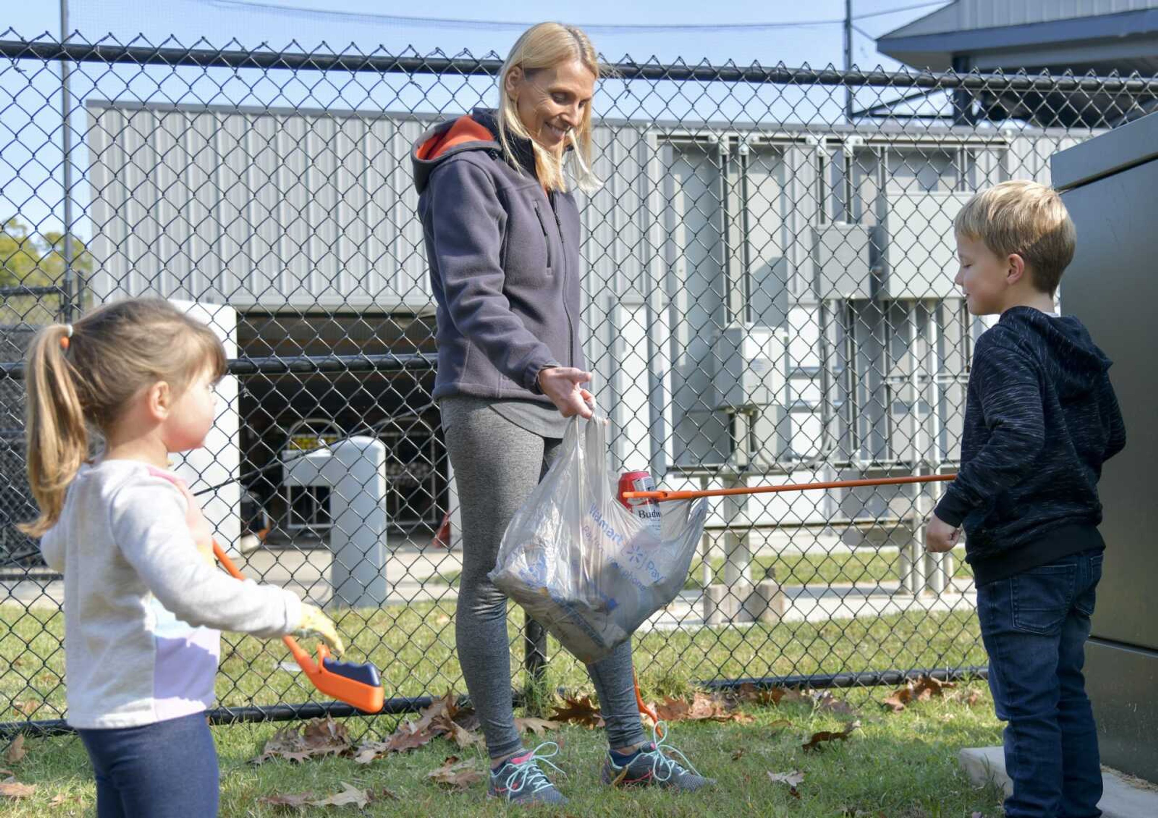 Sue Gibbons holds a trash bag while Oliver Sayers, 5, puts a can in it at Capaha Park in Cape Girardeau on Oct. 17, 2020.