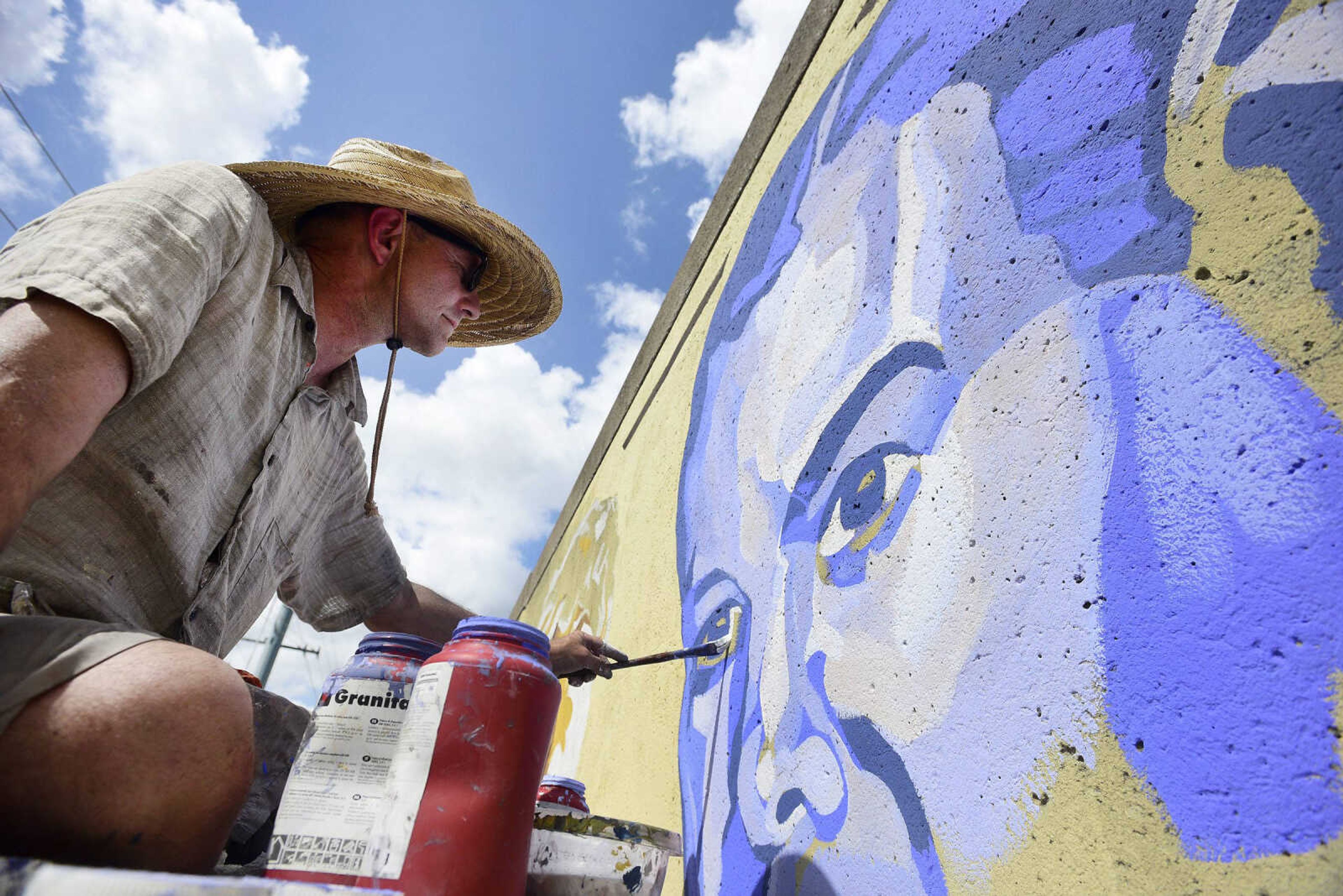 Craig Thomas paints a mural of the late Gen. Seth McKee on Thursday.