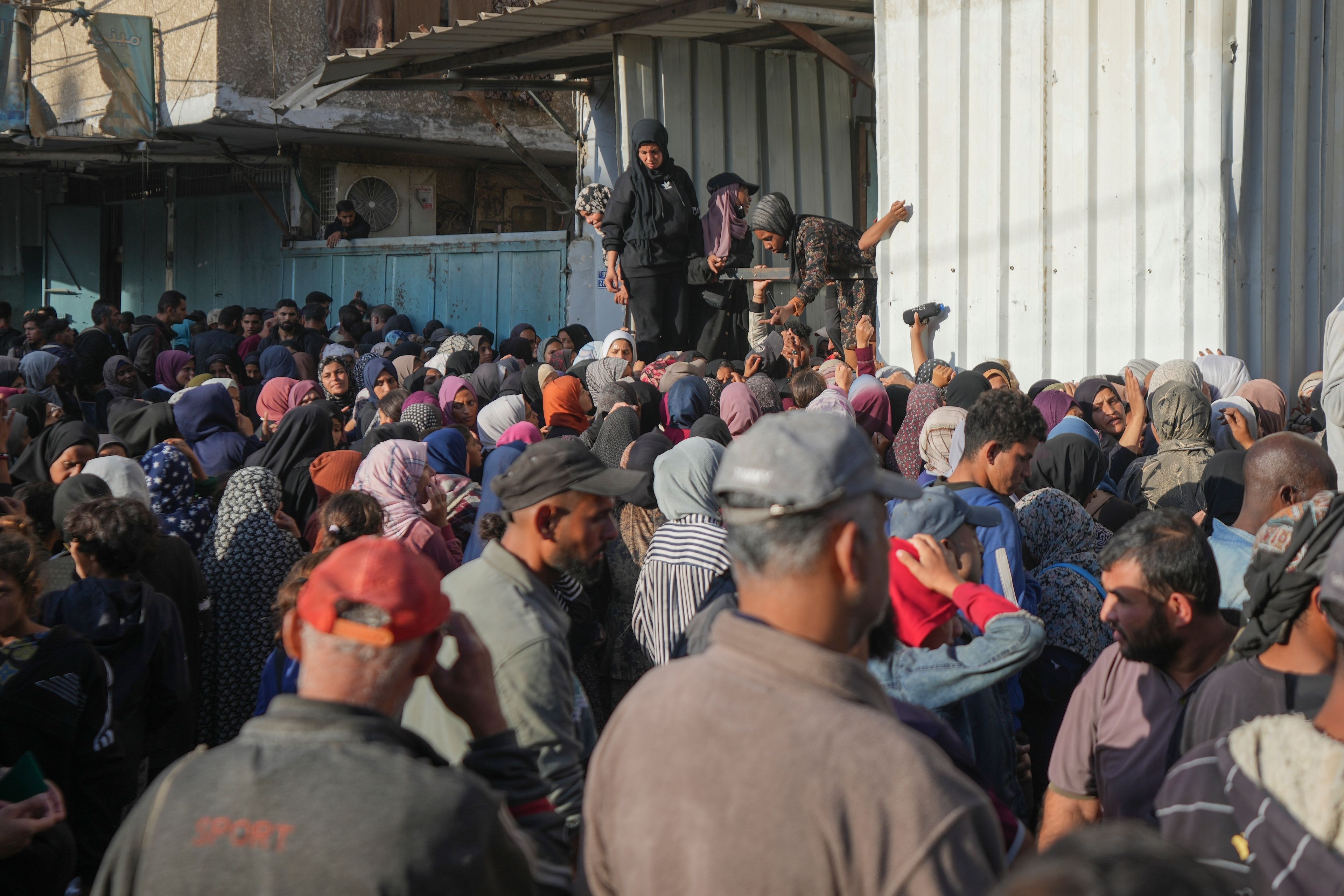 Residents gather in front of a bakery to get their share of bread in Deir al-Balah, Gaza Strip, Thursday, Nov. 21, 2024. (AP Photo/Abdel Kareem Hana)