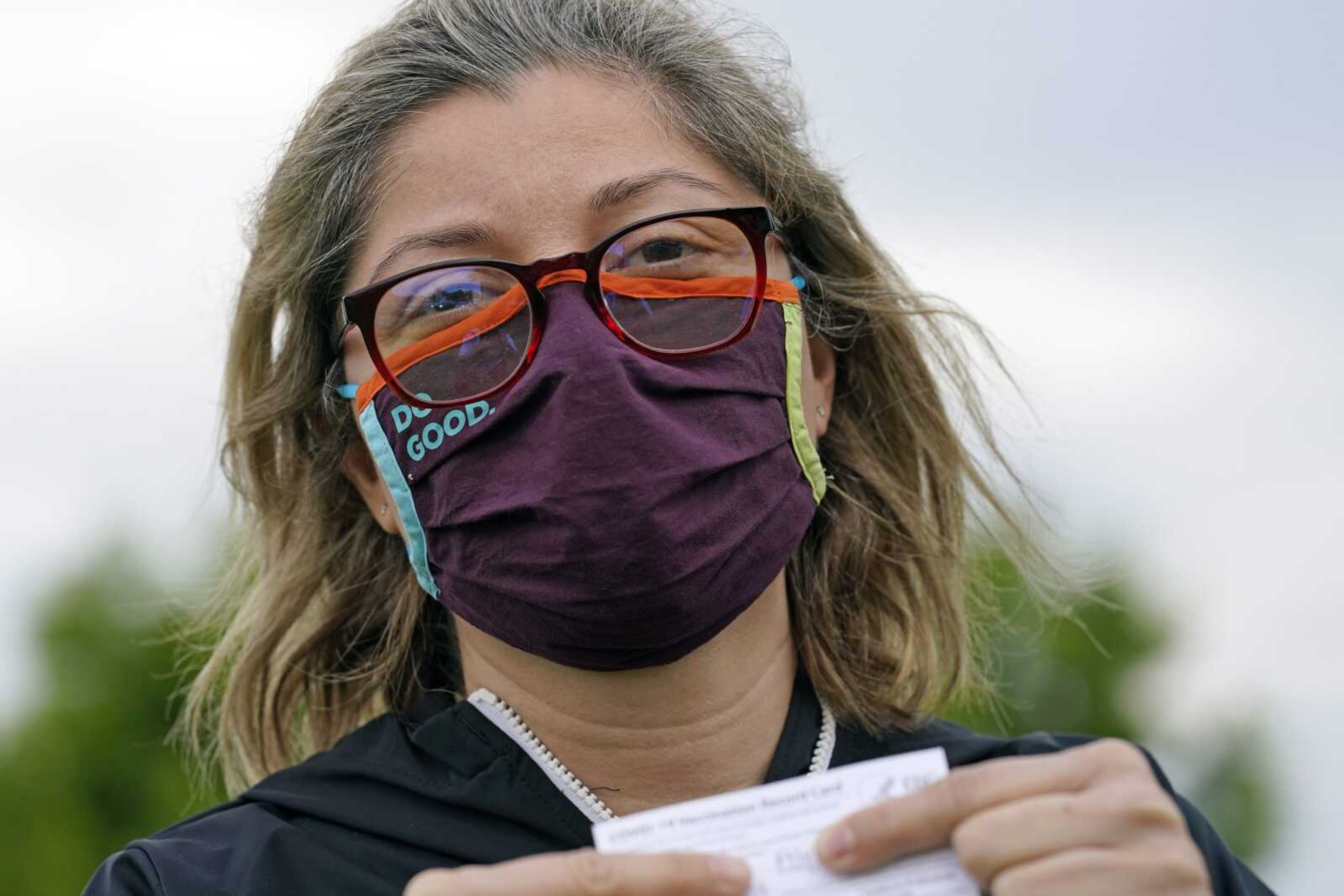 Alejandra poses with her vaccination card after getting her second Moderna COVID-19 shot Monday in Pasadena, Texas. Alejandra, a dentist who also lives in Monterrey, Mexico, said she decided to seek a vaccine in the U.S. shortly after losing her mother to COVID-19 in February.