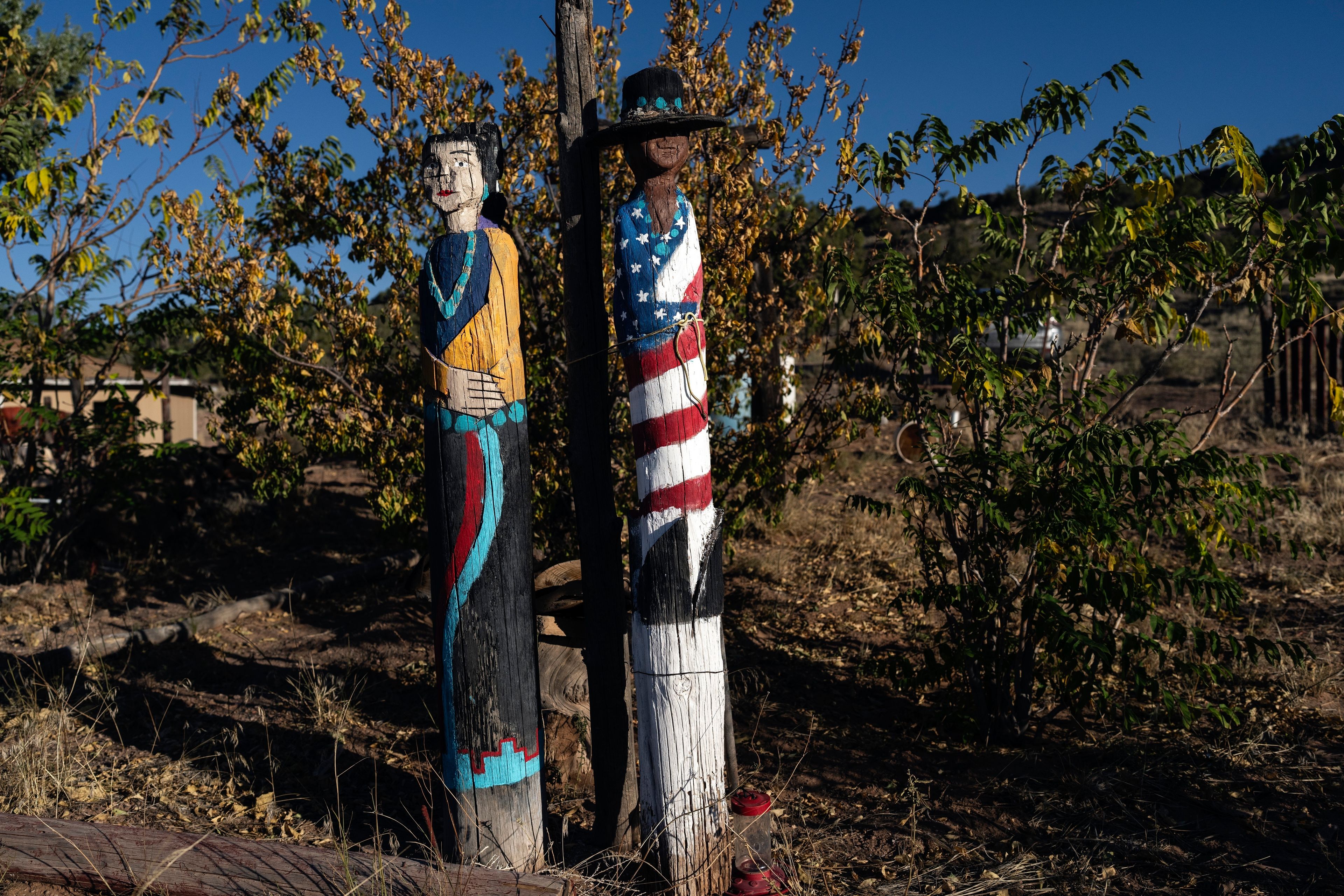 Native wood sculptures adorn the yard of Felix Ashley on the Navajo Nation in Dilkon, Ariz., Saturday, Oct. 12, 2024. (AP Photo/Rodrigo Abd)