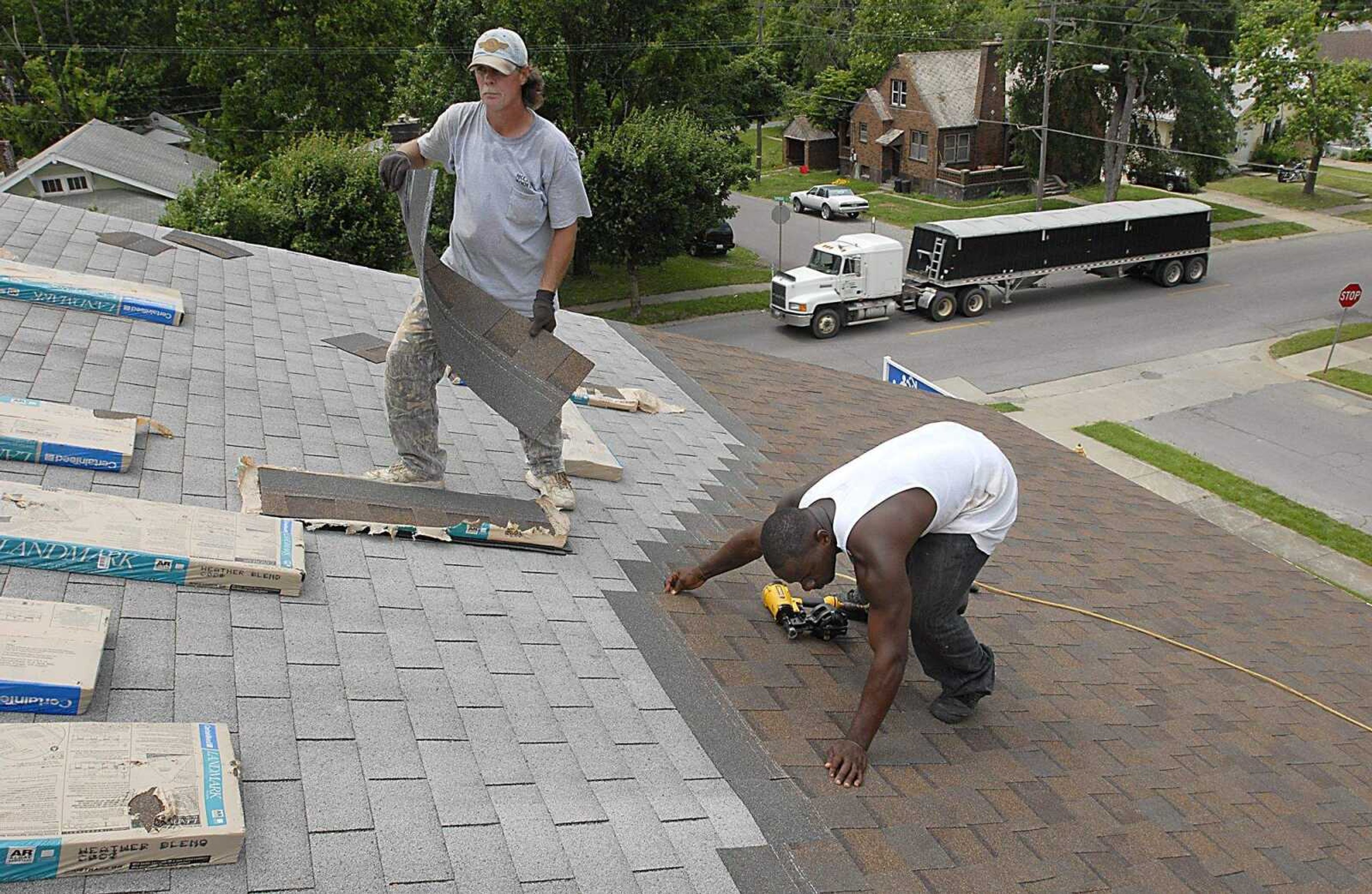 KIT DOYLE ~ kdoyle@semissourian.com
Larry Mobley, left, and Malik Maxwell, of McClure Roofing, put new shingles on the Cape Area Family Resource Center Wednesday, June 4, 2008, along South Sprigg St. in Cape Girardeau. After several problems earlier in the year, many local residents are eager to see the center back on its feet.