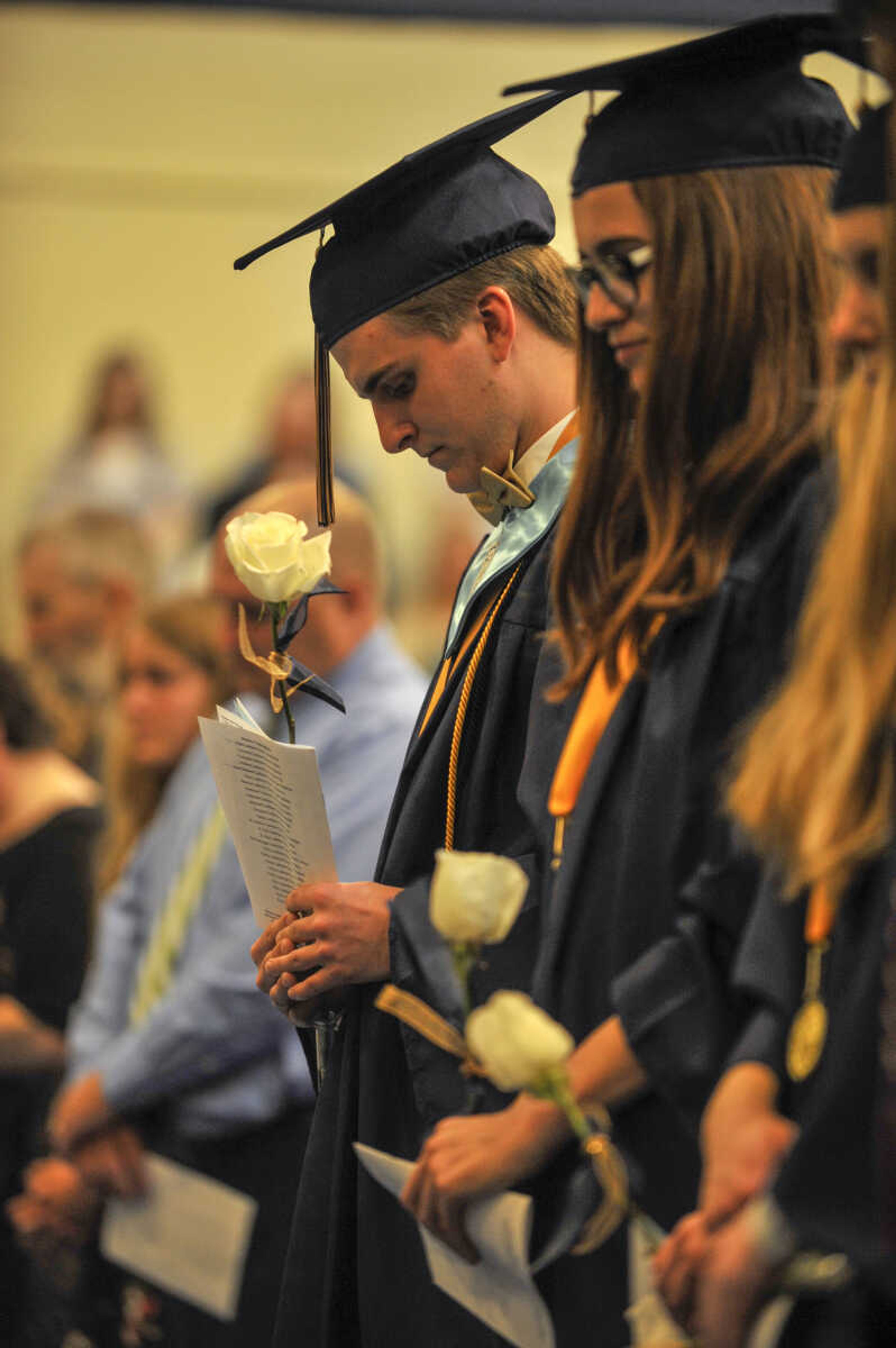 A student prays during commencement at Saxony Lutheran High School on Sunday, May 16, 2021.