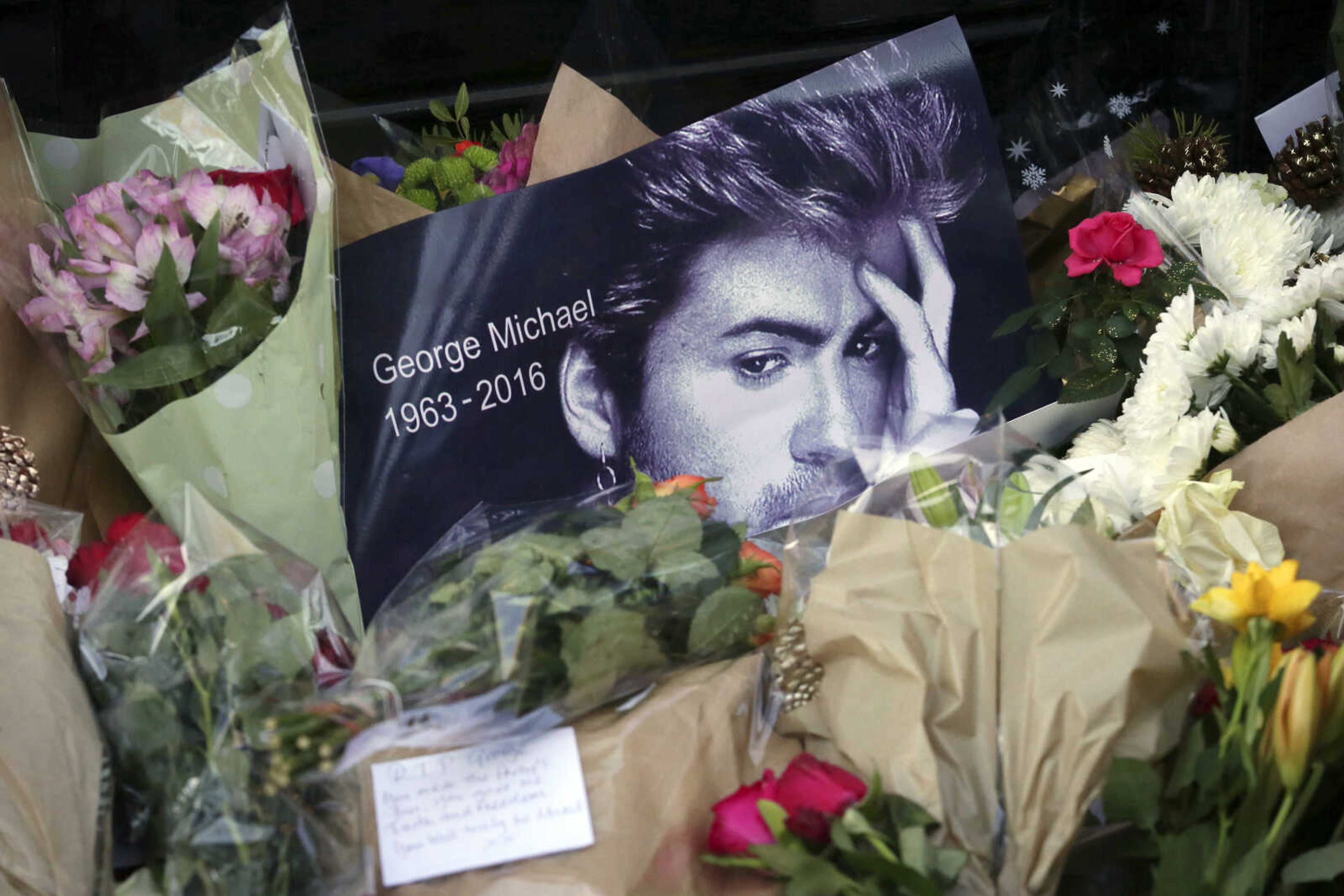 Tributes left outside the home of British musician George Michael are seen Monday in London. Michael died Sunday; he was 53.