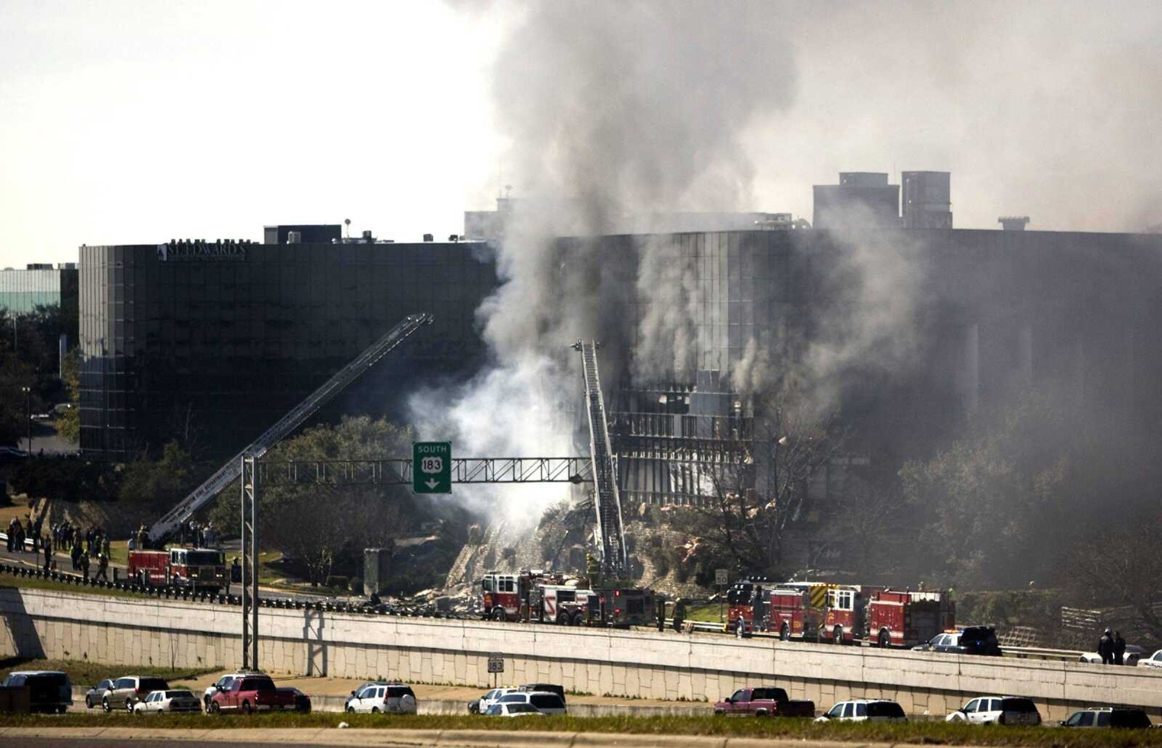 Smoke billows from a seven-story building after a small private plane crashed into the building  in Austin, Texas on Thursday Feb. 18, 2010. (AP Photo/Austin American-Statesman, Jay Janner/)