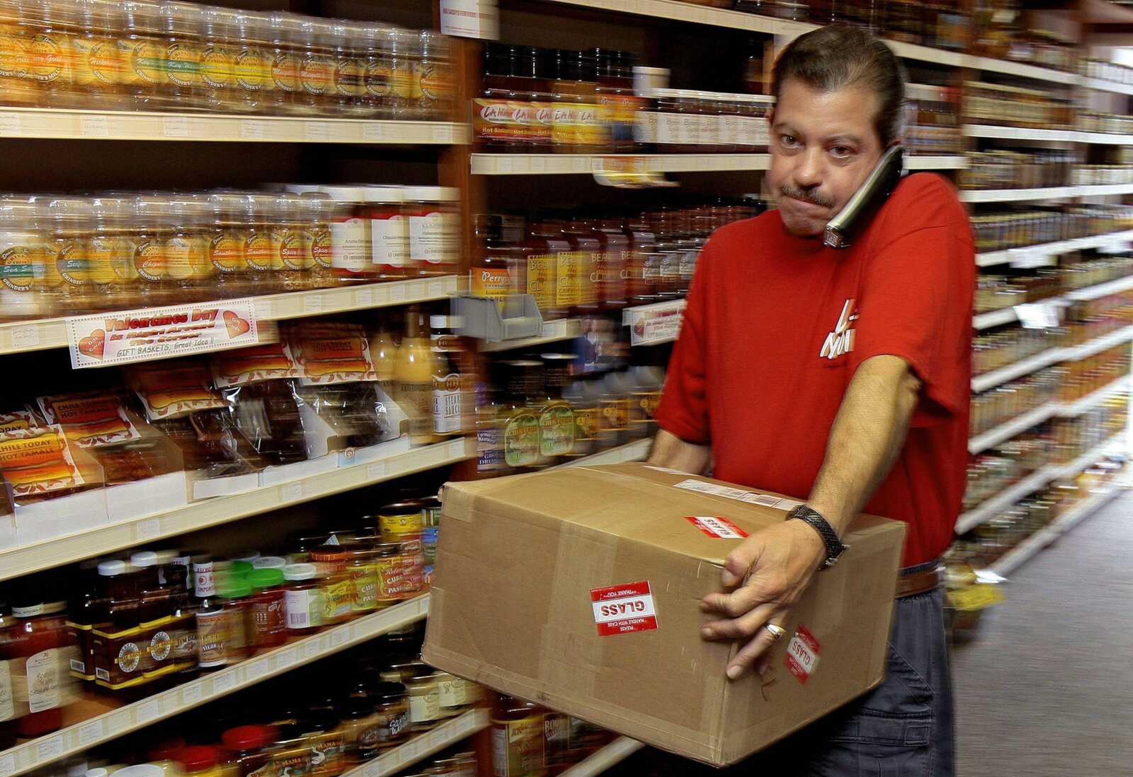 Chuck Rizzo unpacked boxes at his store, Big Daddy's Fiery Foods, Friday morning in Sarasota, Fla. Besides cutting back his family's spending, Rizzo is now working seven days a week and putting in 13-hour days after opening the store last month. Sales were strong early on but have crashed in January, and he's worried about the declining economic trends. (CHRIS O'MEARA ~ Associated Press)