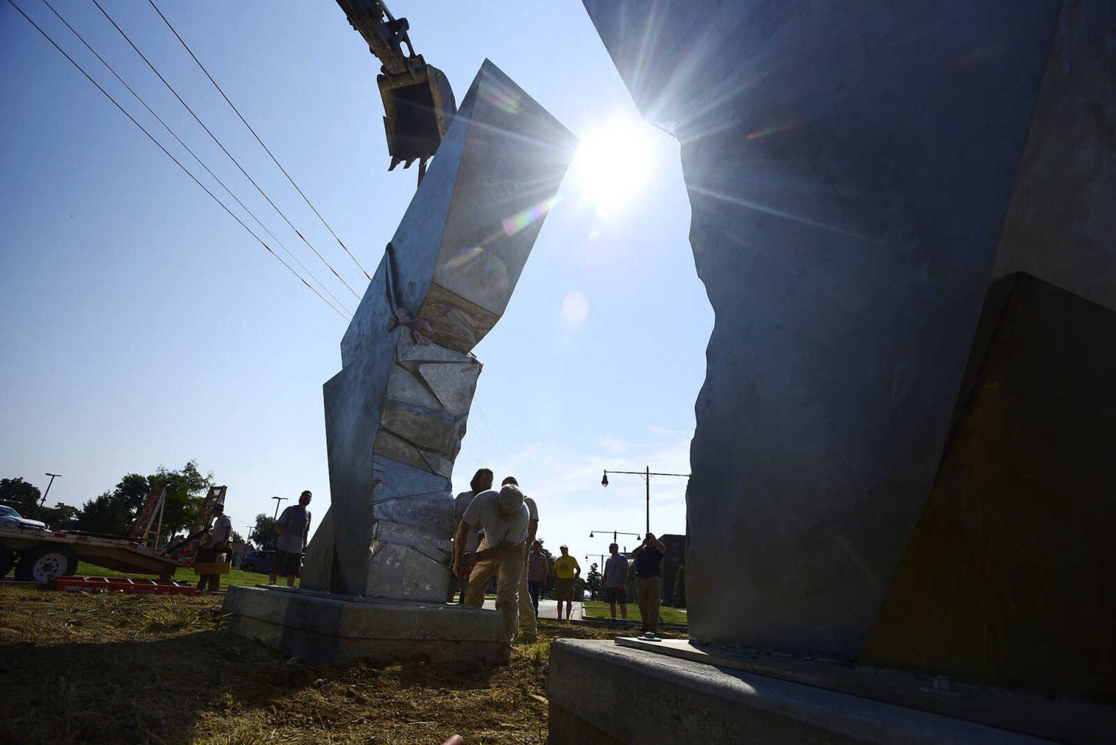 Cape Girardeau Parks and Recreation employees install the second piece of Chris Wubbena's 14-foot sculpture, "Commence", in the Fountain Street roundabout on Monday, July 24, 2017, near the River Campus in Cape Girardeau.