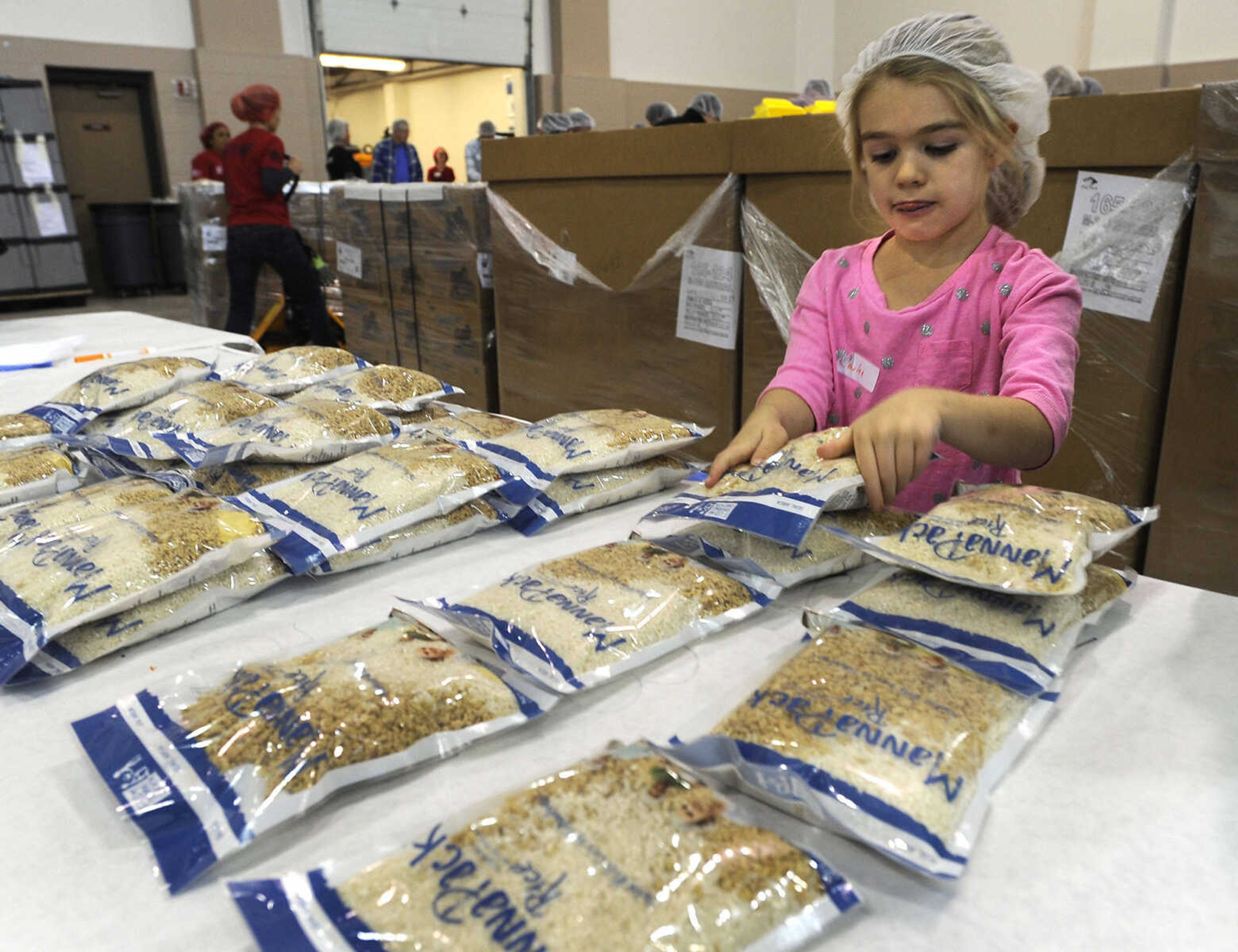 Carlee Copeland stacks MannaPack rice bags at the Feed My Starving Children MobilePack event Sunday, Dec. 7, 2014 at the Osage Centre in Cape Girardeau.