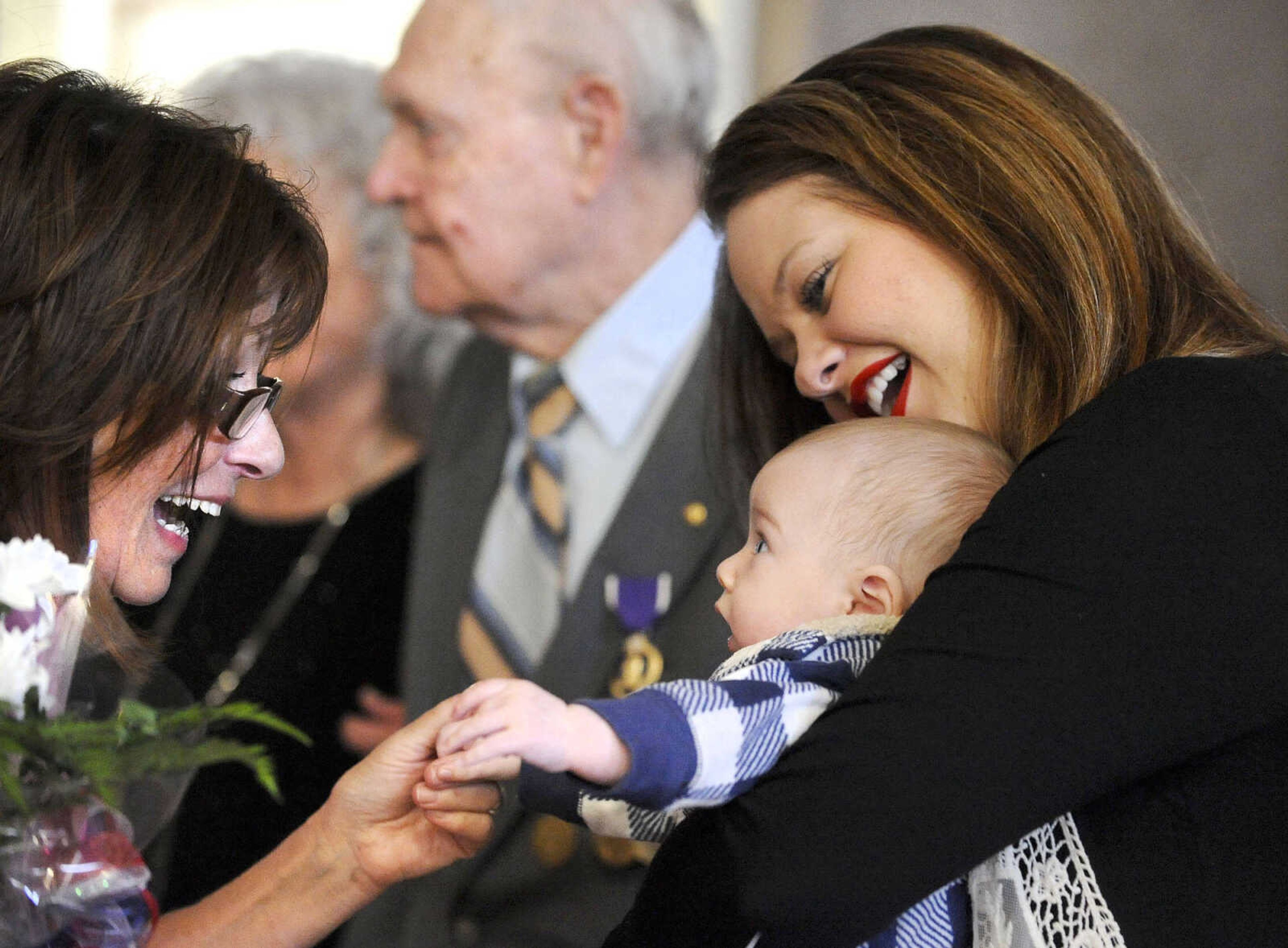 LAURA SIMON ~ lsimon@semissourian.com

Diane Gomersall, left, visits with three-month-old John Casen Rogers and his mother Bailey on Monday, March 21, 2016, after the living history event honoring the WWII lost crew of the Flying Fortress 812, and the medal presentation to Sgt. Clifford Heinrich at Alma Schrader Elementary. Heinrich was presented with an American Campaign Medal, WWII Victory Medal, Army Good Conduct Medal, a WWII Lapel Button, European-African-Middle Eastern Campaign Medal and the Purple Heart for his service during WWII during Monday's presentation.