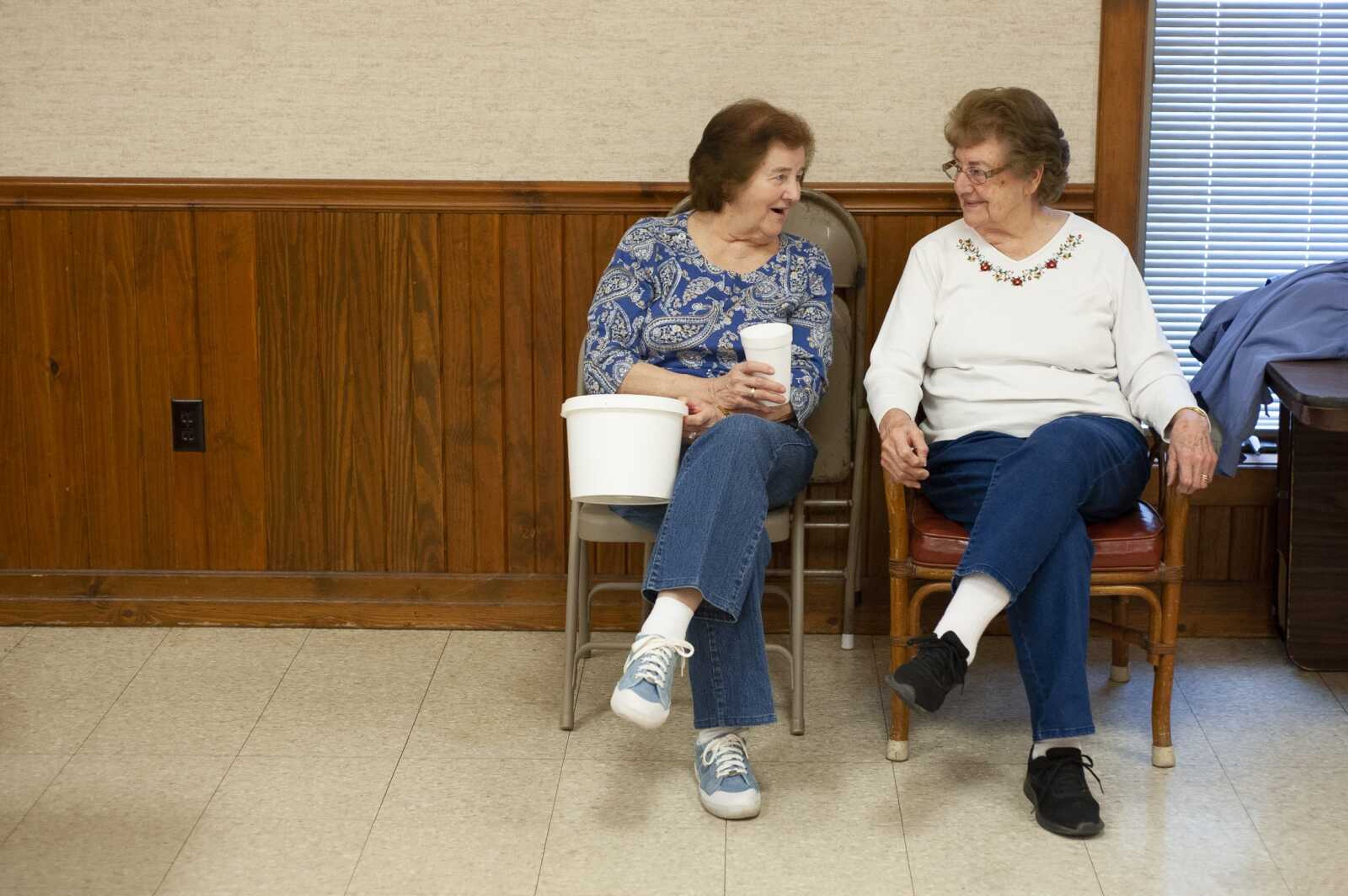 Rose Kern, left, and Irene Blattel, sisters from Scott City and Kelso, Missouri, respectively, chat while collecting tickets during a fish fry Friday at Scott City Knights of Columbus.