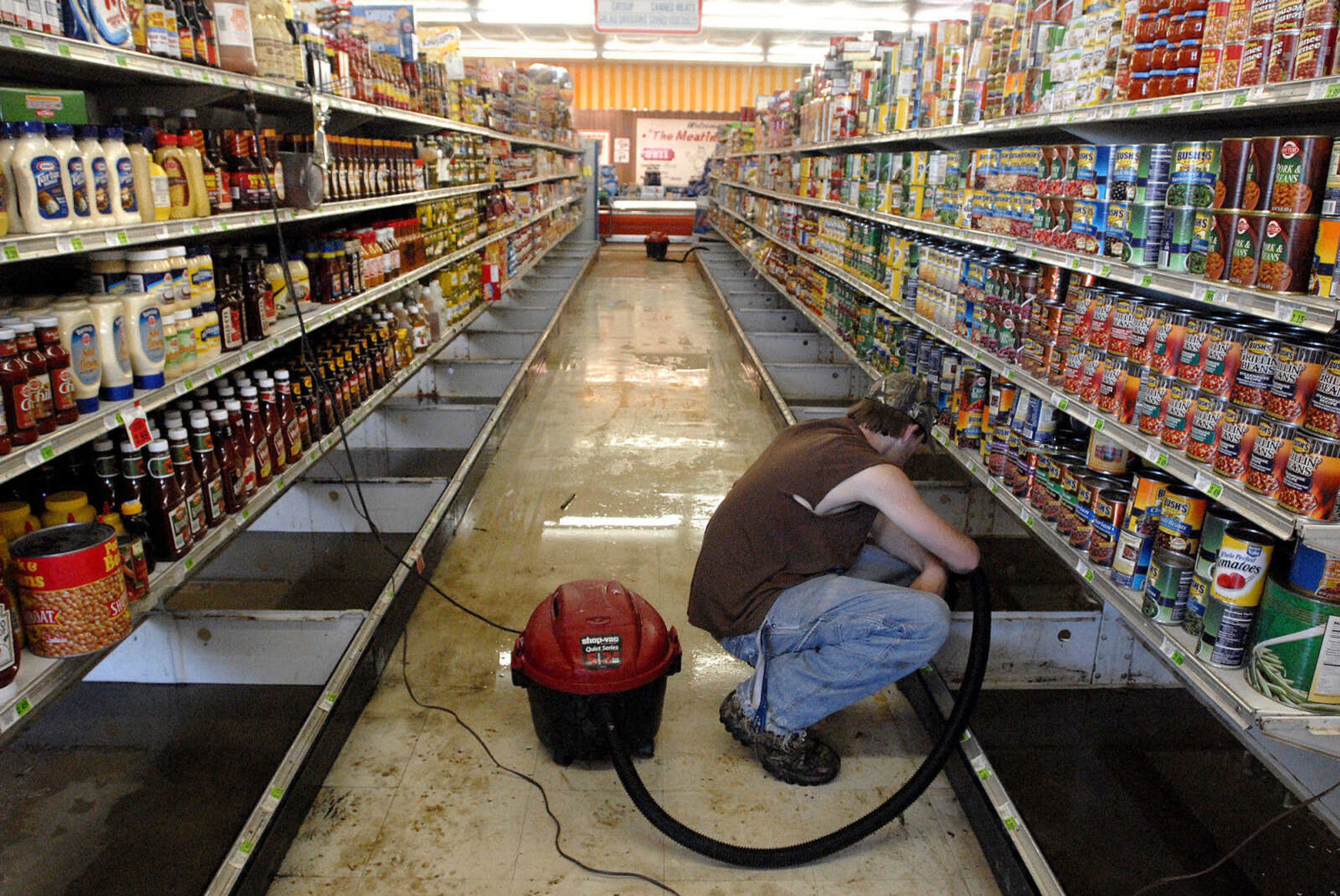 LAURA SIMON~lsimon@semissourian.com
Foodtown employee Travis Poole cleans the bottom shelves in the Olive Branch, Ill. grocery store Thursday, May 5, 2011. The store had 16 inches of water inside when floodwaters were at their highest.