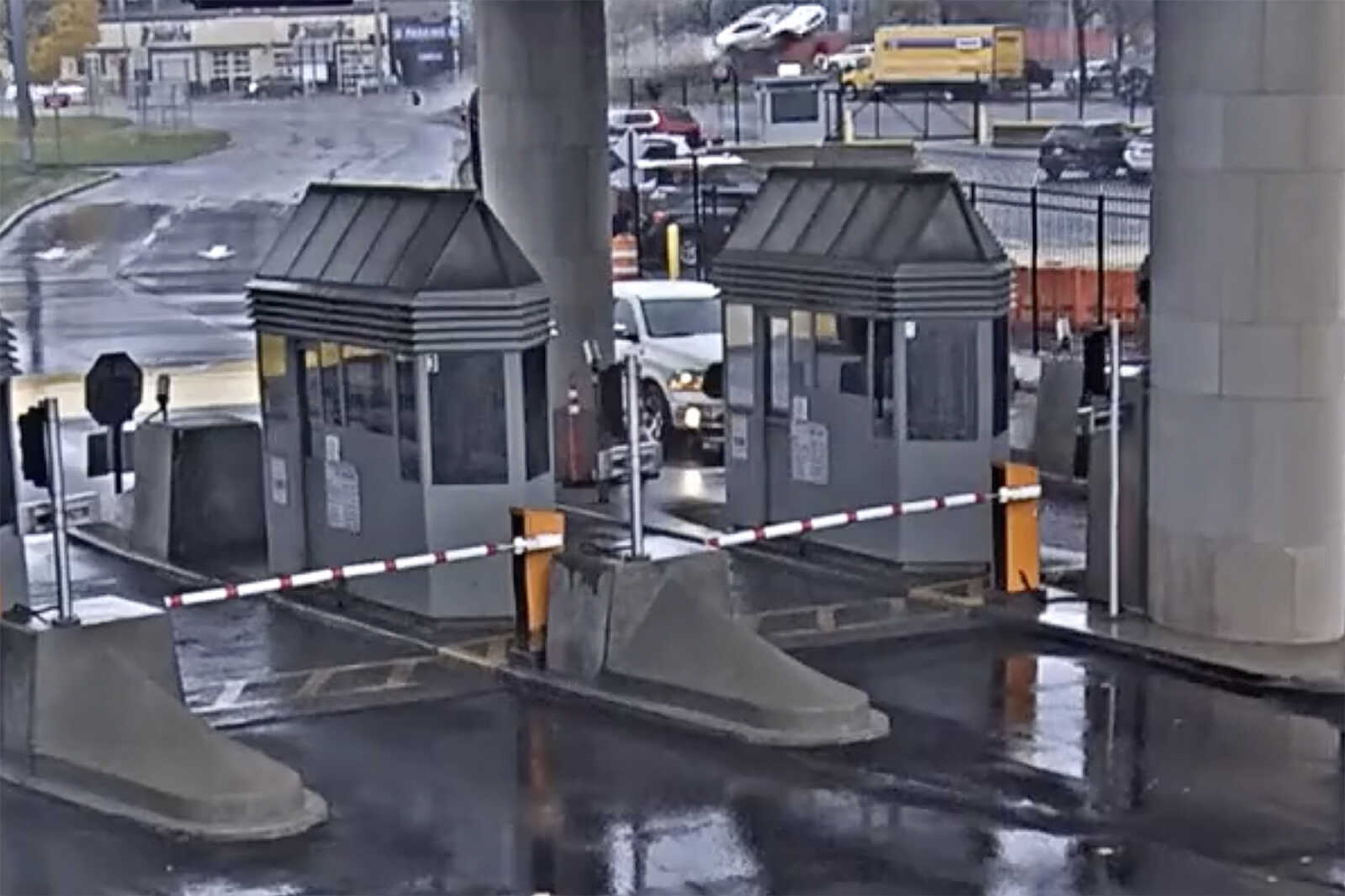 In this image taken from security video, a light colored vehicle, top center, flies over a fence into the Rainbow Bridge customs plaza Wednesday in Niagara Falls, New York. A vehicle exploded at a checkpoint on the American side of a U.S.-Canada bridge in Niagara Falls, leaving two people dead and prompting the closing of four border crossings in the area, authorities said.