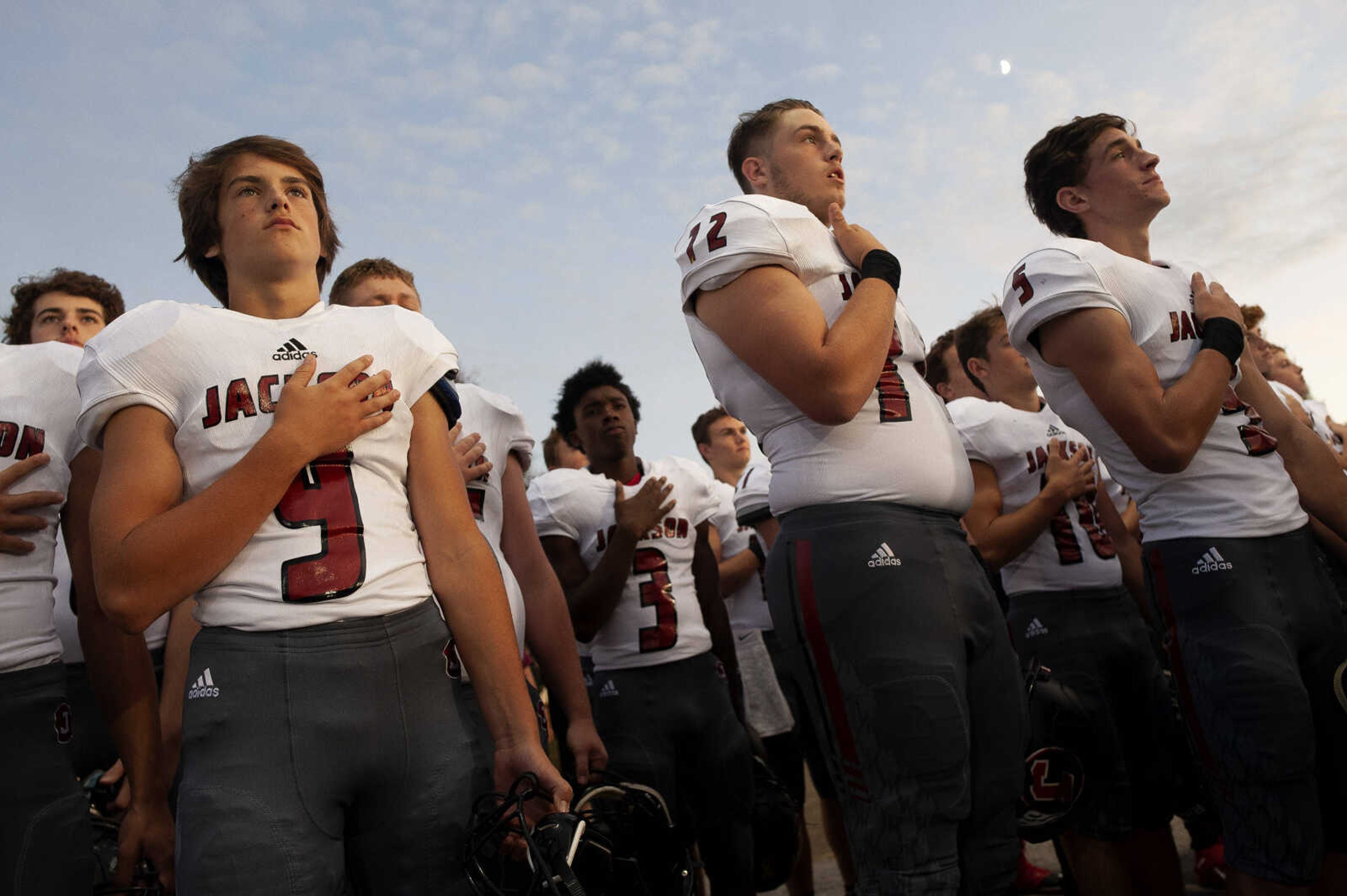 Jackson Indians including front row from left: Steven Schneider (9), Cameron Byrd (72) and Patrick Boyd (5) stand for the national anthem before the start of their matchup against Farmington on Friday, Oct. 4, 2019, in Farmington, Missouri.