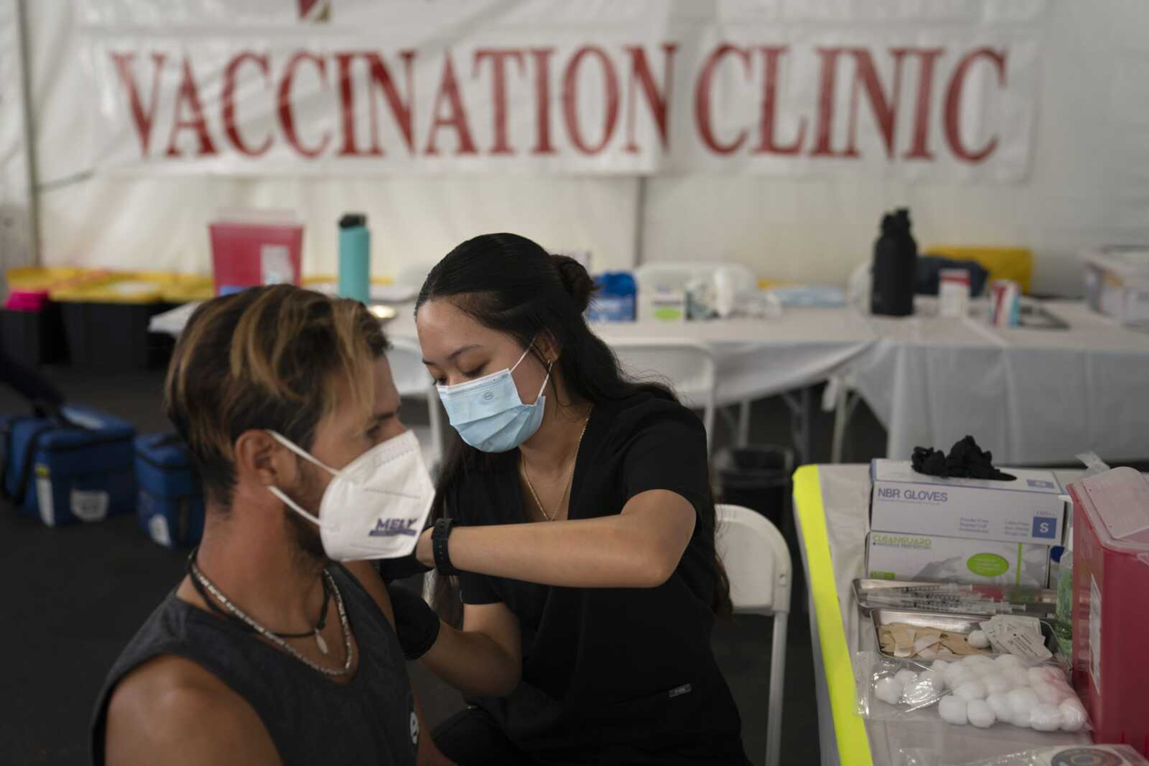 FILE - In this Aug. 28, 2021, file photo, registered nurse, Noleen Nobleza, center, inoculates Julio Quinones with a COVID-19 vaccine at a clinic set up in the parking lot of CalOptima in Orange, Calif. A decline in COVID-19 cases in the United States over the last several weeks has given overwhelmed hospitals some relief, but administrators are bracing for yet another possible surge as cold weather drives people indoors. An estimated 70 million eligible Americans remain unvaccinated, providing kindling for the highly contagious delta variant. (AP Photo/Jae C. Hong, File)