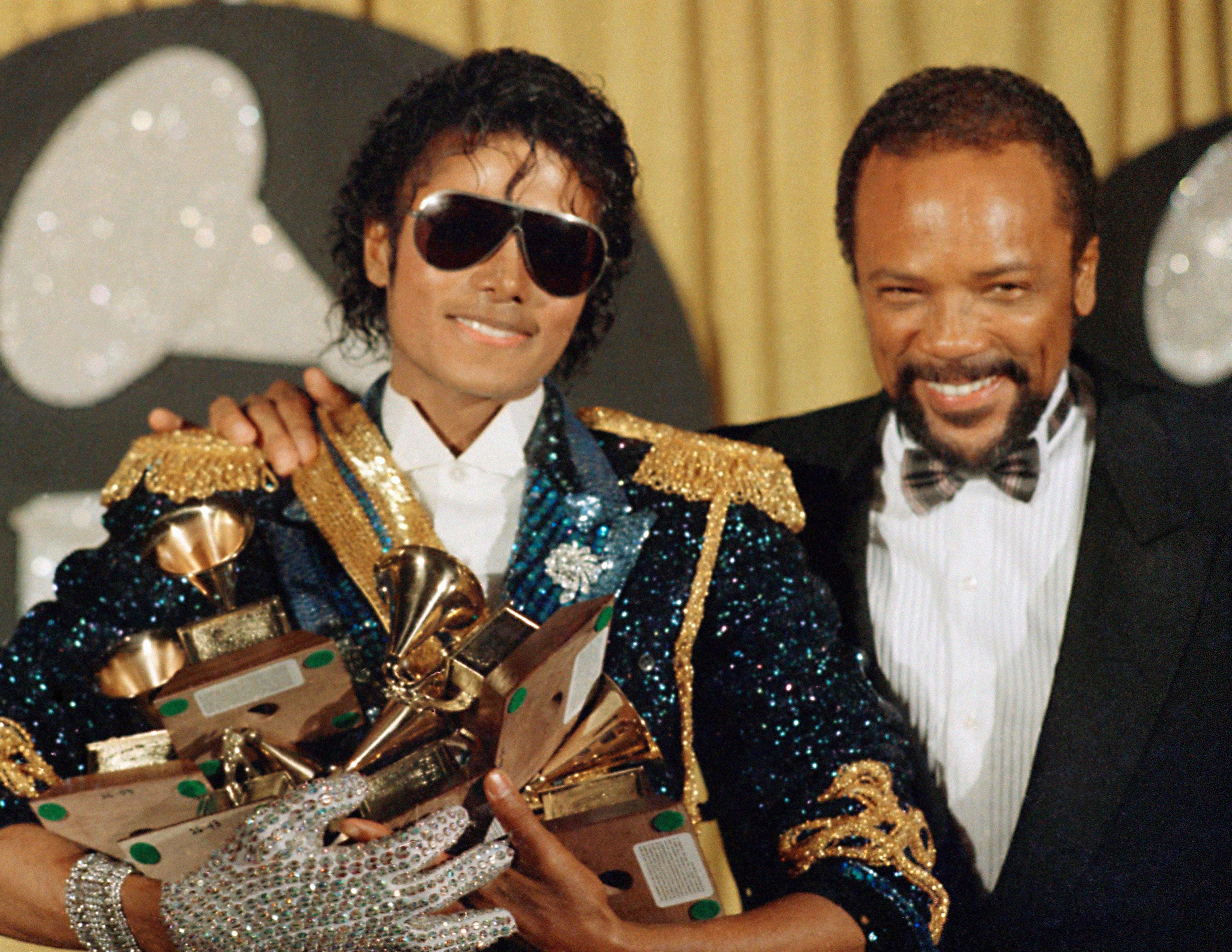 FILE - Michael Jackson, left, holds eight awards as he poses with Quincy Jones at the Grammy Awards in Los Angeles, Feb. 28, 1984. Quincy Jones died at age 91. (AP Photo/Doug Pizac, File)