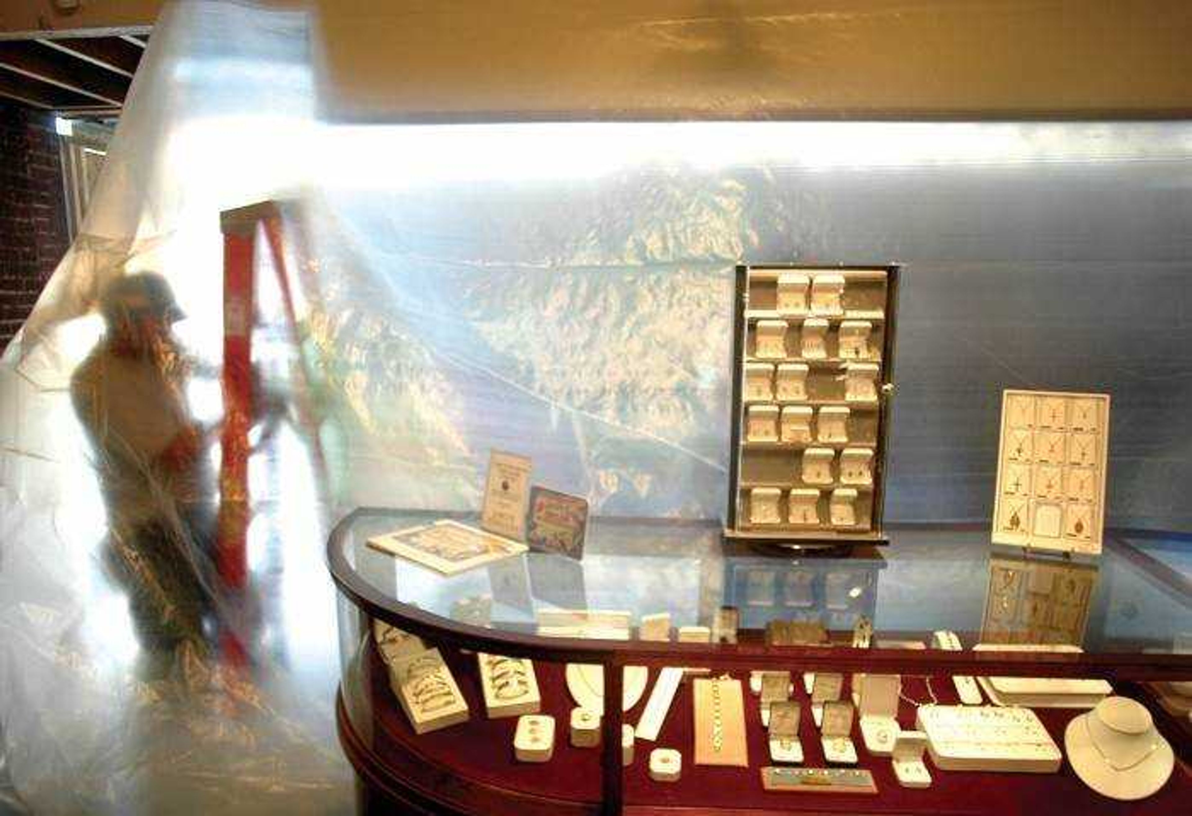 Brandon Beninati worked behind a sheet of plastic hung to protect the jewelry displays during renovations at Lang Jewelers in Cape Girardeau on Friday. (Aaron Eisenhauer)