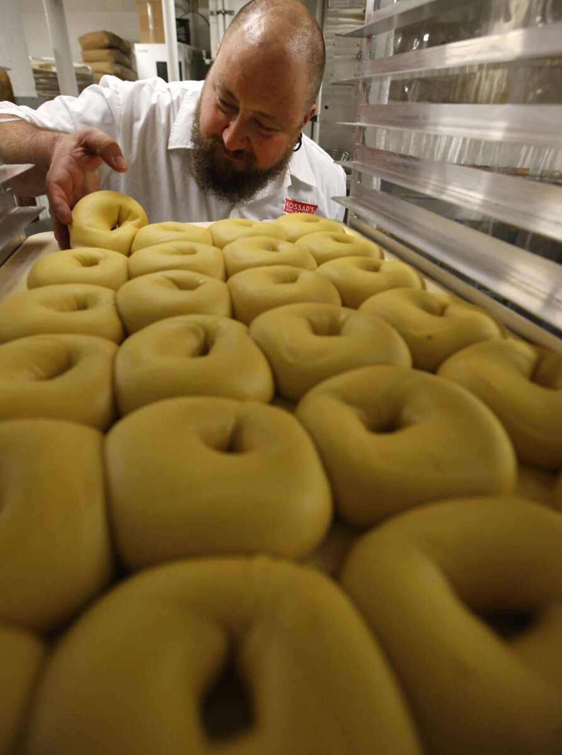 Kossar's Bagels and Bialys co-owner and classically-trained French chef David Zablocki checks a tray of bagels Thursday, May 26, at his store in New York. Zablocki went in search of an old-school baker when he was testing bagel recipes. "A New York bagel is really a magical thing," he said, "partly because of the water and the mineral content we have in the water." (AP Photo/Kathy Willens)