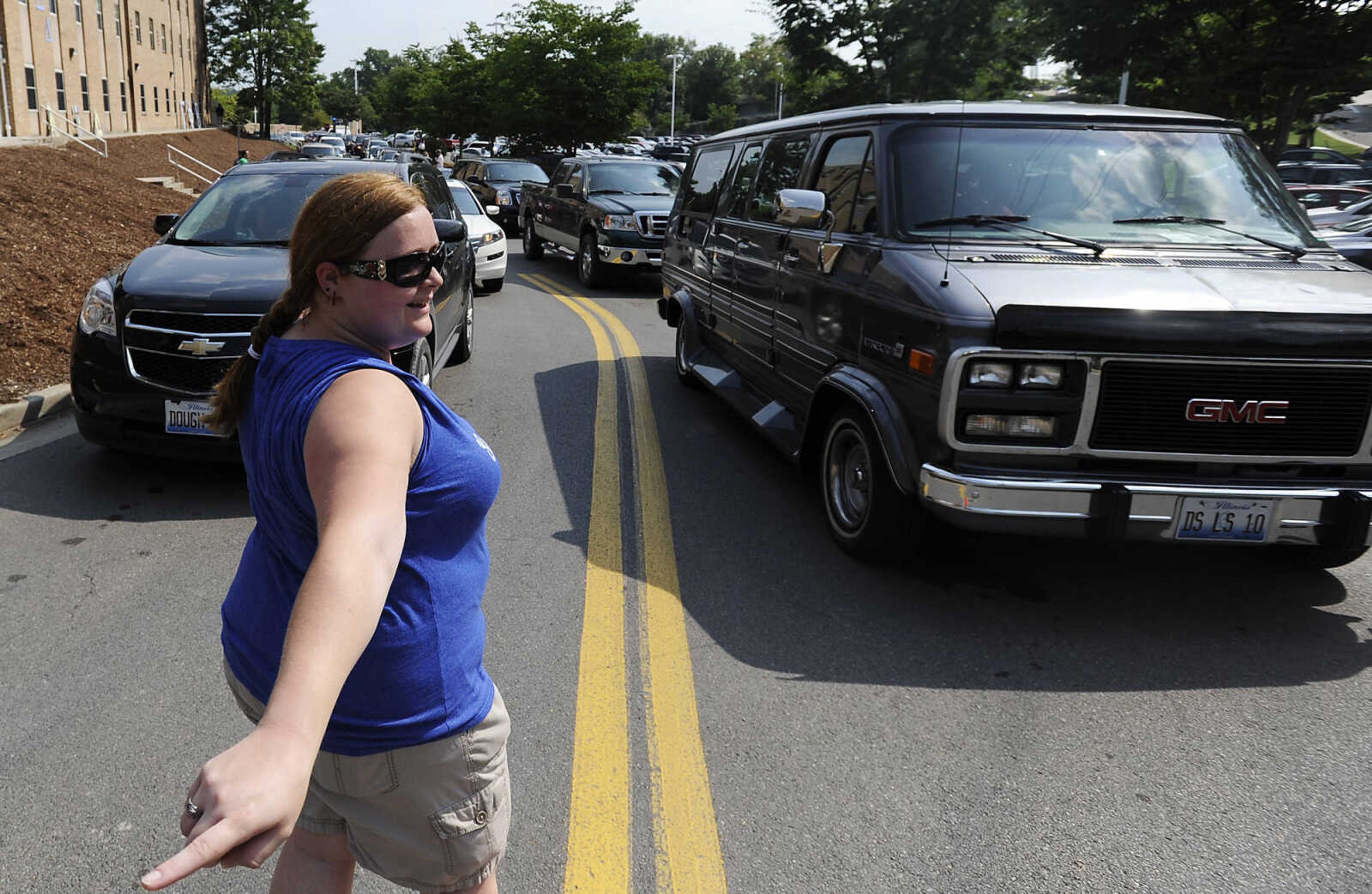 Christina Pohrer directs traffic at the Towers residence halls during move in day Thursday, Aug. 22, at Southeast Missouri State University. Several campus organizations provided volunteers to help the approximately 1,100 students who moved into on-campus housing between 6 a.m and 1 p.m. Traffic was backed up onto Sprigg Street and wait times in excess of a half-hour were reported by some.