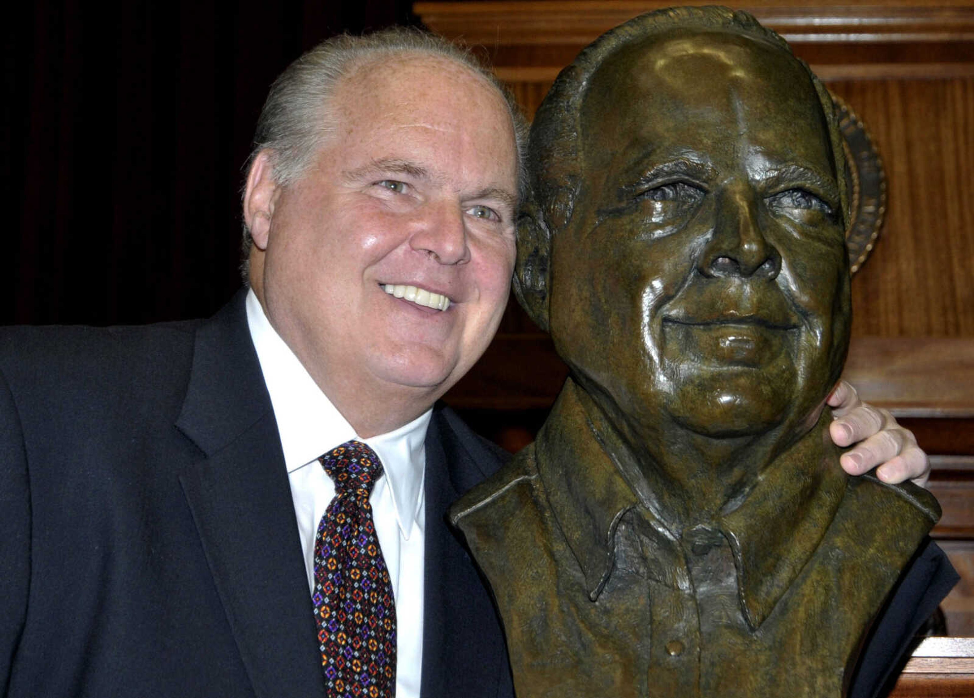 Conservative commentator Rush Limbaugh poses with a bust in his likeness during a  ceremony inducting him into the Hall of Famous Missourians on May 14, 2012, in the state Capitol in Jefferson City, Missouri.