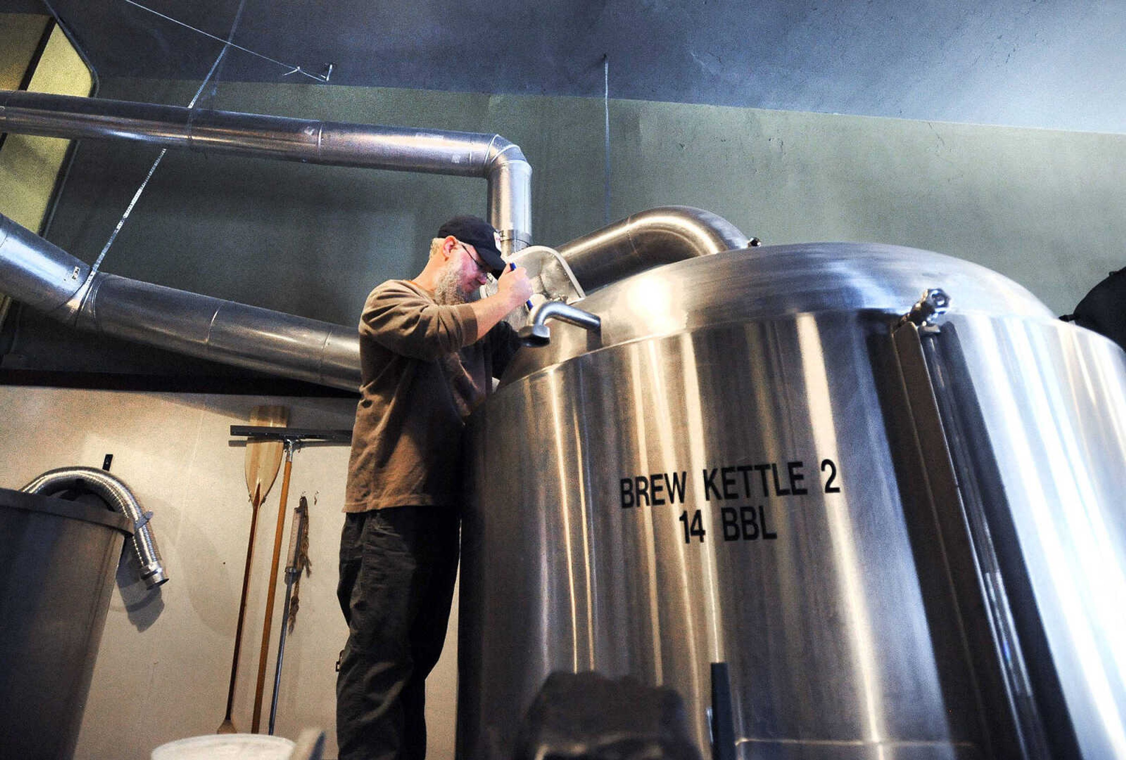 Mike Mills, brewmaster at Buckner's, checks the temperature in the brew kettle Tuesday in downtown Cape Girardeau. Mills was brewing a batch of Bee's Sneeze Honey Wheat beer. (Laura Simon)