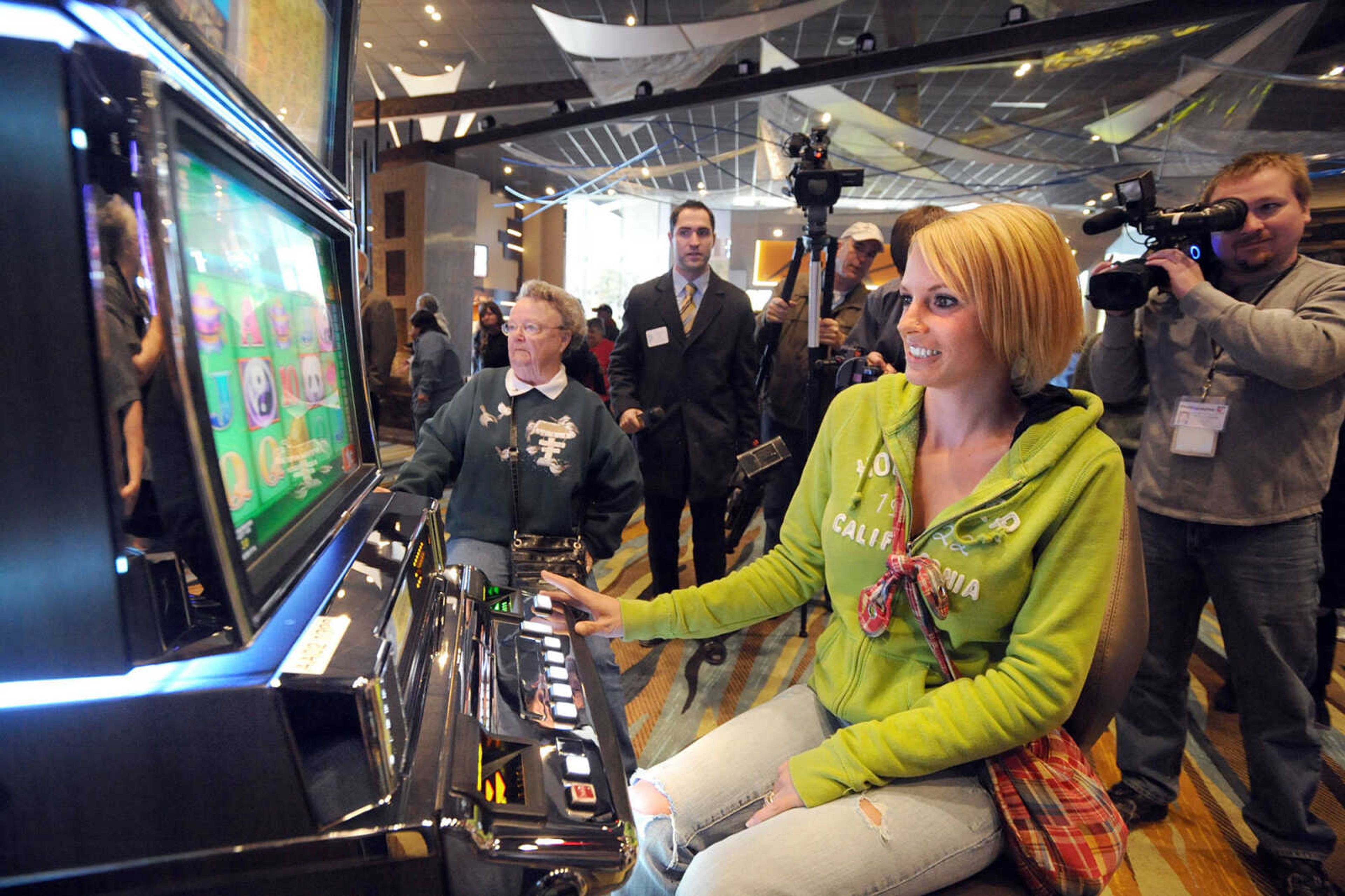 LAURA SIMON ~ lsimon@semissourian.com
The media lines up for a shot of Jami Carter as she plays the first slot machine Tuesday, Oct. 30, 2012 on opening day of Isle Casino Cape Girardeau.