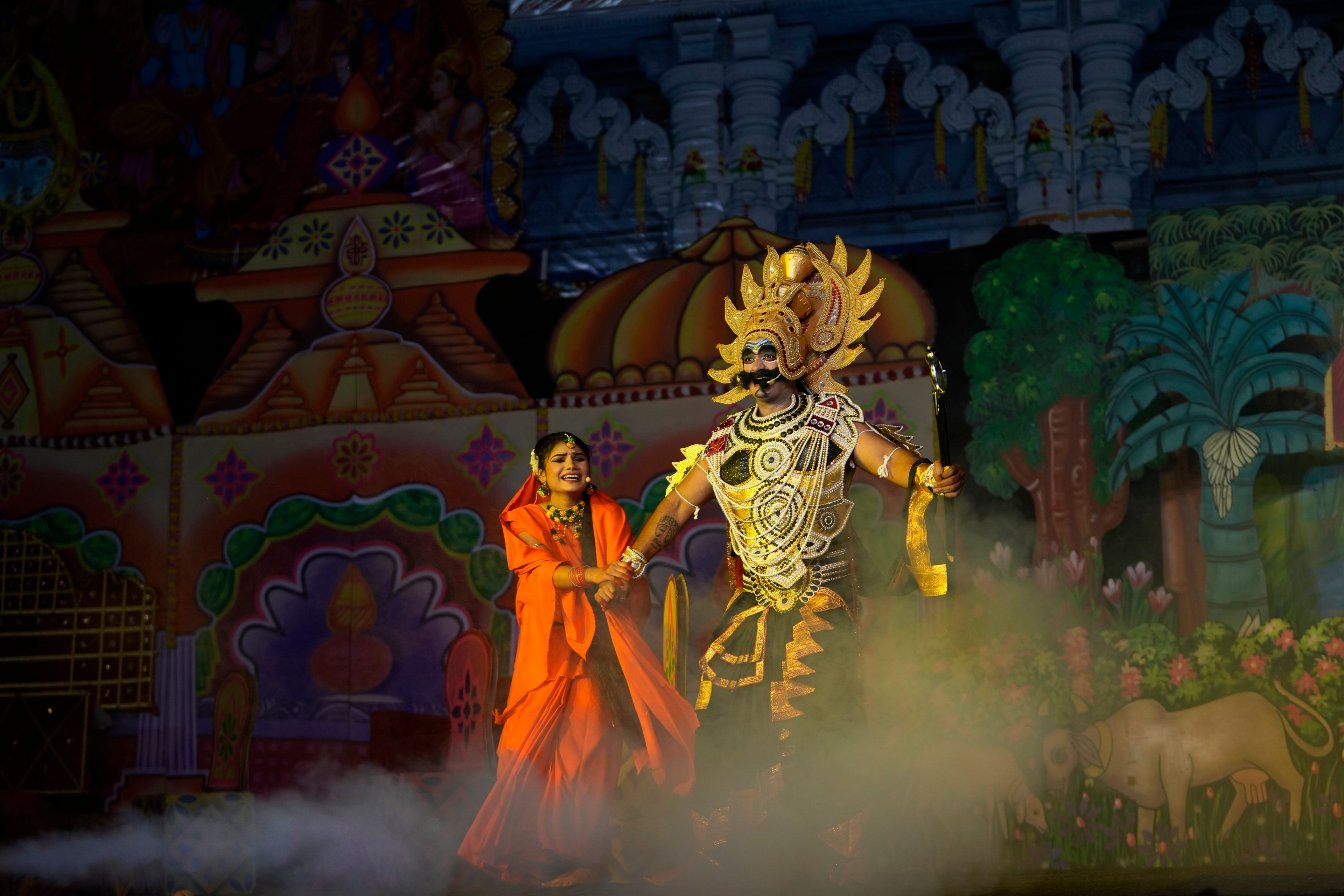 Vikas Sirswal, 32, right, playing the character of the demon king Ravana and Hitanshi Jha, 21, playing the character of Sita perform onstage during Ramleela, a dramatic folk re-enactment of the life of Hindu god Rama according to the ancient Hindu epic Ramayana, in New Delhi, India, Wednesday, Oct. 9, 2024. (AP Photo/Manish Swarup)