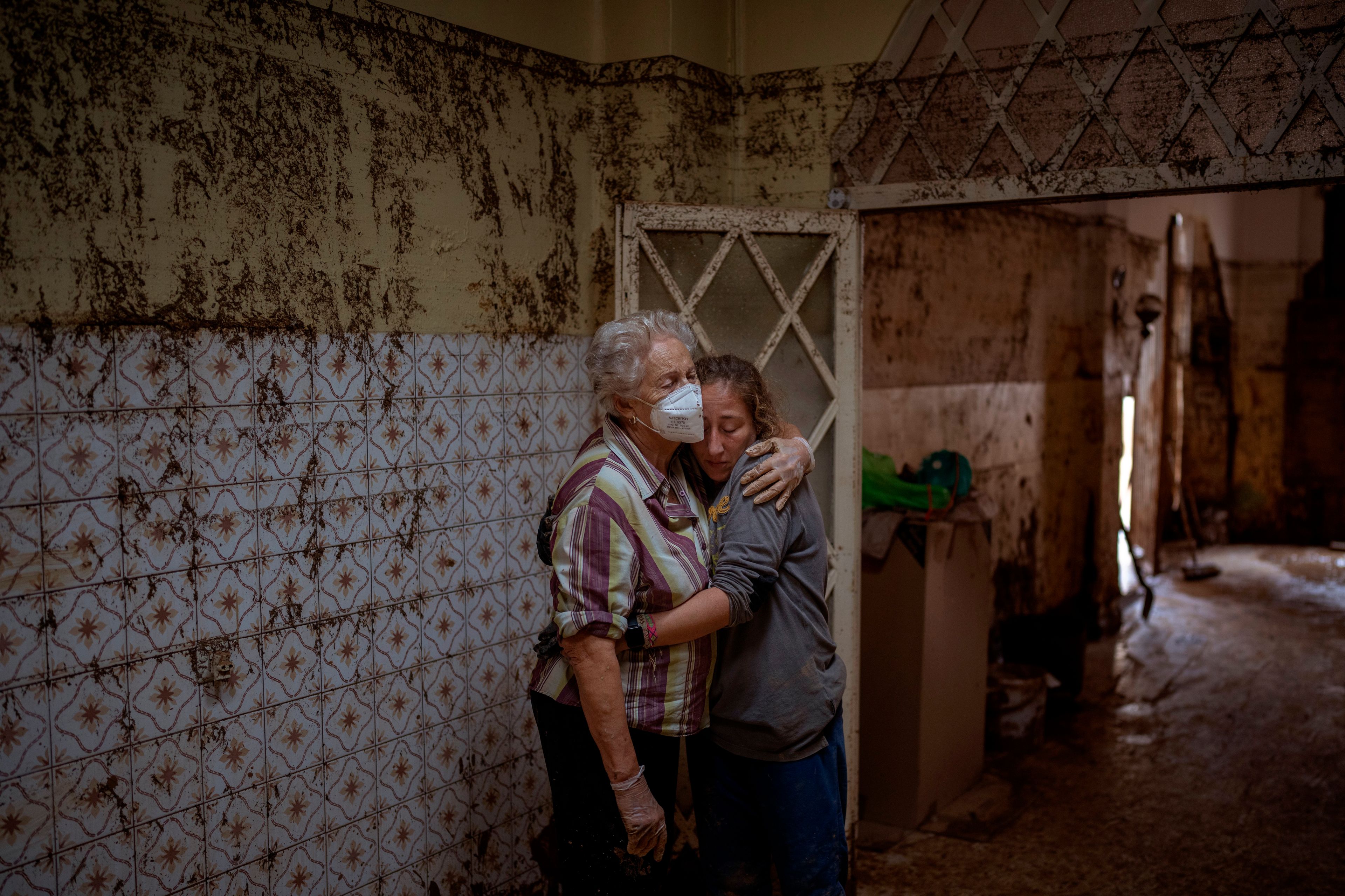 Vero Almarche, 36, right, hugs her neighbor Maria Munoz, 74, who was born in the house where they are photographed and which was destroyed by flooding in Masanasa, Valencia, Spain, Wednesday, Nov. 6, 2024. (AP Photo/Emilio Morenatti)