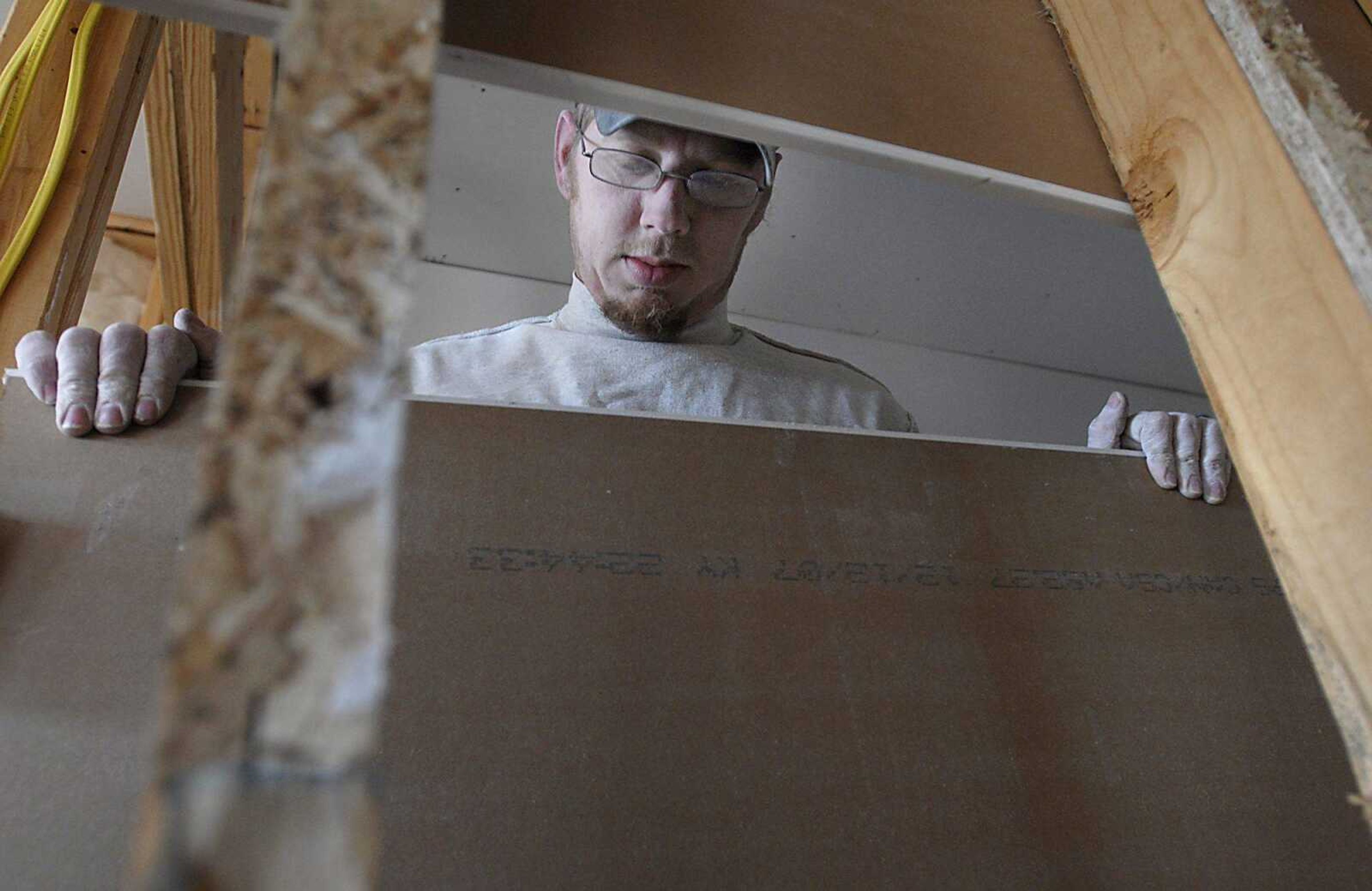 Joe Simmons lined up drywall Tuesday while working on units at Walden Park, just north of Cape Gir~ardeau.