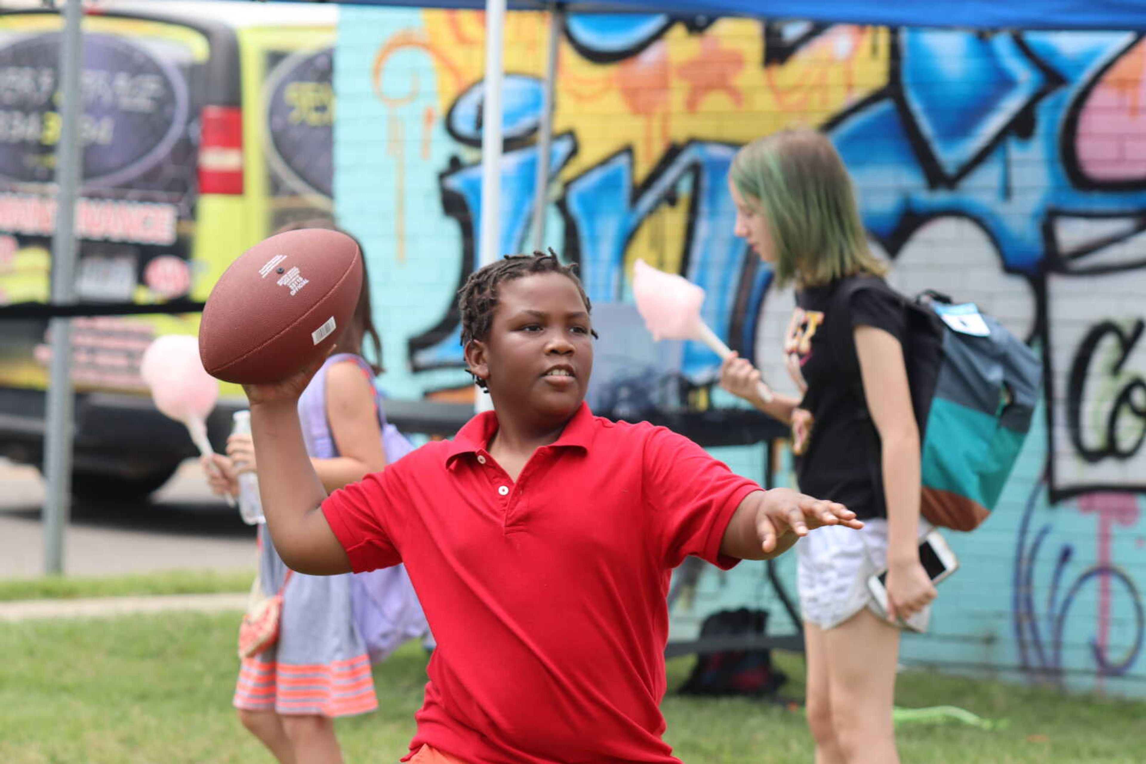 A child throws a football around with friends at the Back to School Bash on Saturday.