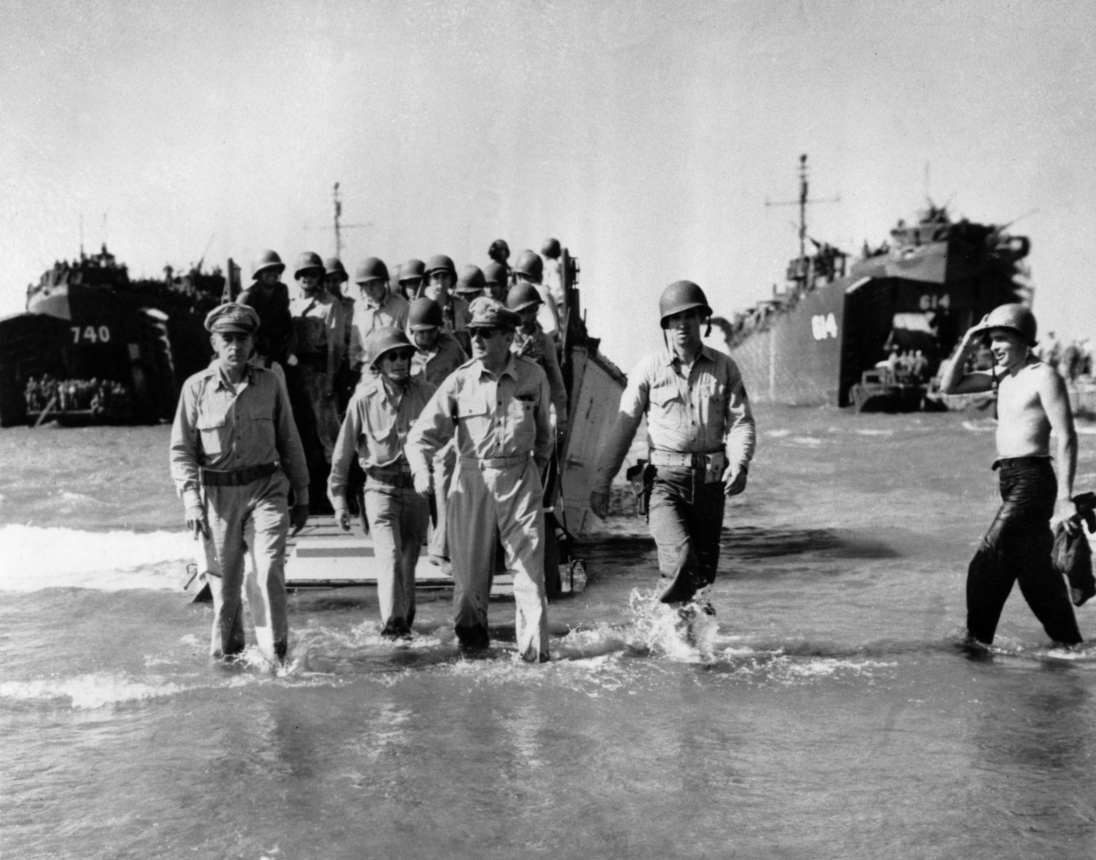 Fulfilling his promise to return to the Philippines, Gen. Douglas MacArthur wades ashore on Leyte Island Oct. 20, 1944, after U.S. forces recaptured the beach from the Japanese. At left is Lt. Gen. Richard K. Sutherland, MacArthur's chief of staff, and directly behind MacArthur, in glasses, is Col. Lloyd Lehrbas, the general's aide. 