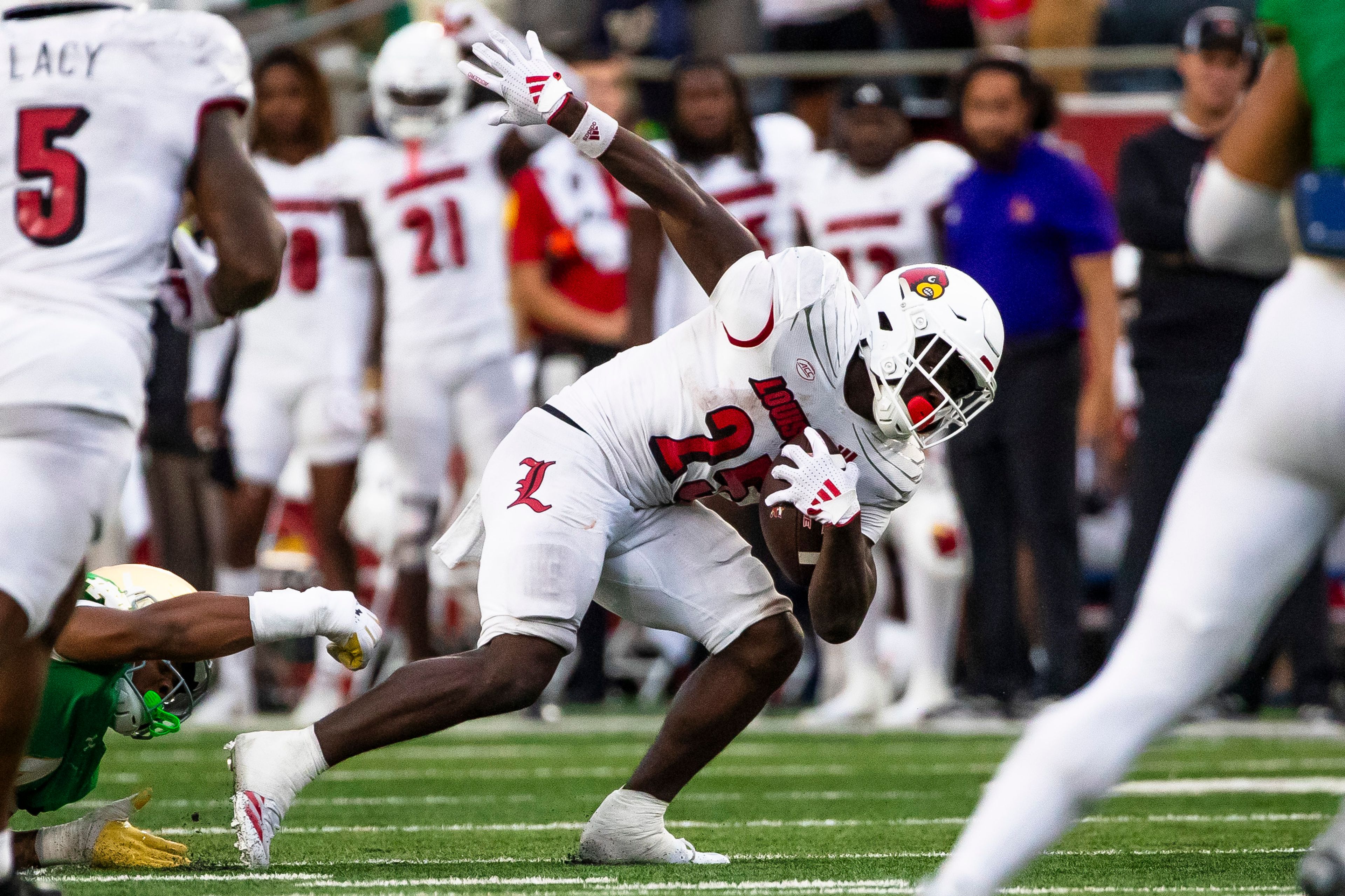 Louisville running back Isaac Brown (25) gets past Notre Dame linebacker Jaiden Ausberry, bottom left, during the second half of an NCAA college football game Saturday, Sept. 28, 2024, in South Bend, Ind. (AP Photo/Michael Caterina)