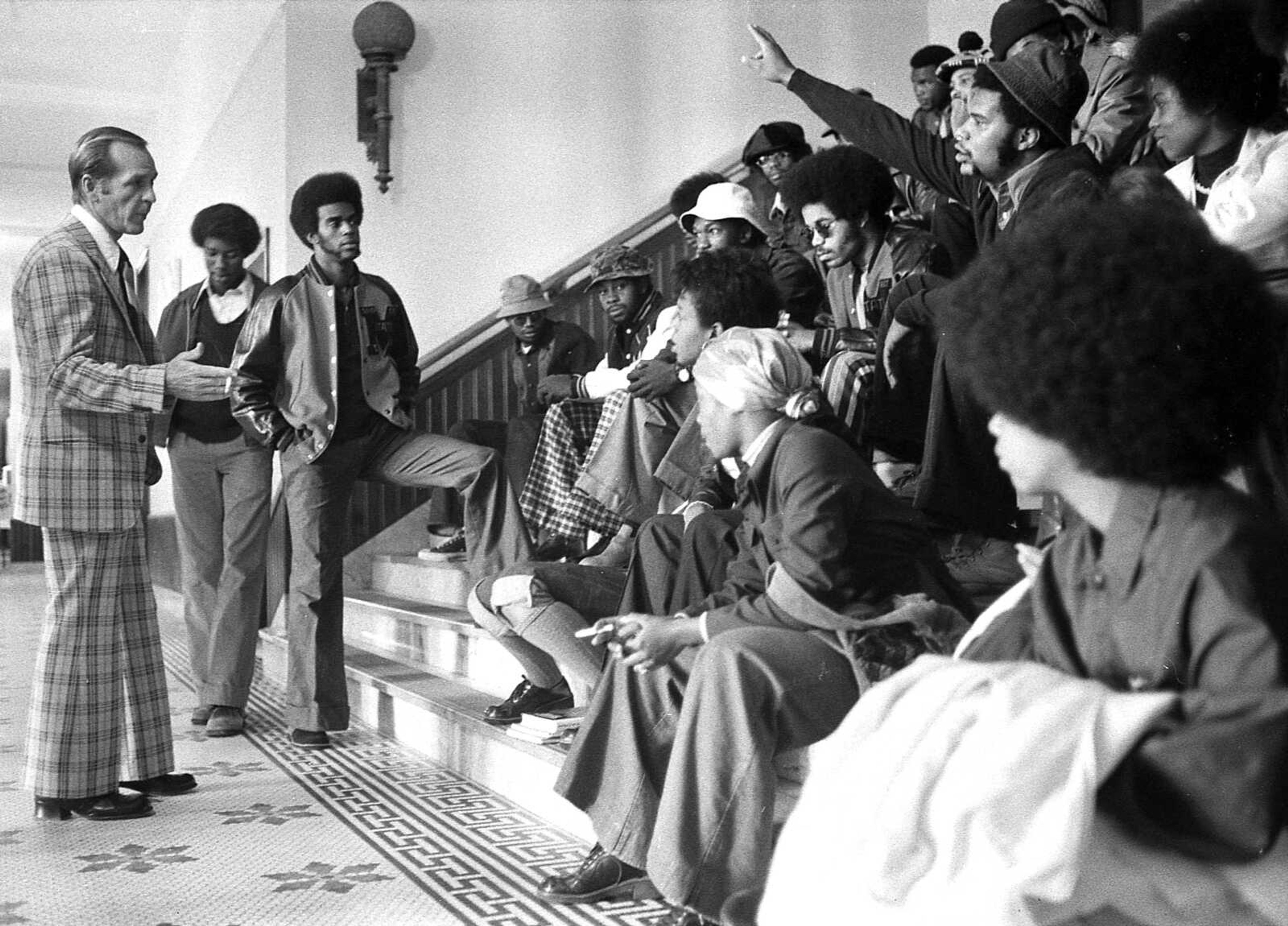 Carroll A. Walker, left, Southeast Missouri State University's dean of students, talks Wednesday, Oct. 17, 1973, with members of the Association of Black Collegiates on steps leading to Academic Hall auditorium. Third from left with foot on steps is Roger Cayce, St. Louis senior and president of the campus ABC. This discussion led to a meeting between university president Mark F. Scully and Black student leaders.