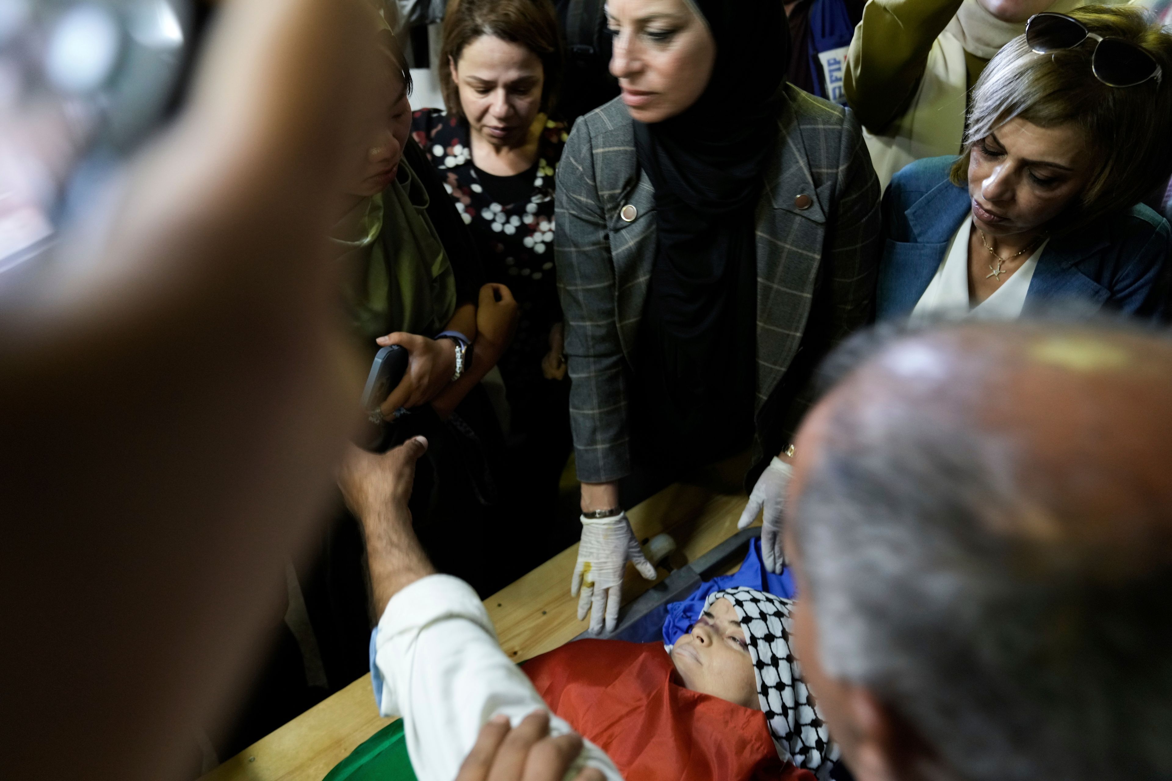 Palestinians look at the body of Turkish-American Aysenur Ezgi Eygi at the hospital morgue in Nablus, West Bank, Sunday, Sept. 8, 2024. Eygi, 26, died after being shot in the head on Friday, Palestinian doctors said. Witnesses to the shooting said the was fatally shot by Israeli forces in a moment of calm after clashes between Palestinians and Israeli forces in the northern West Bank. (AP Photo/Majdi Mohammed)