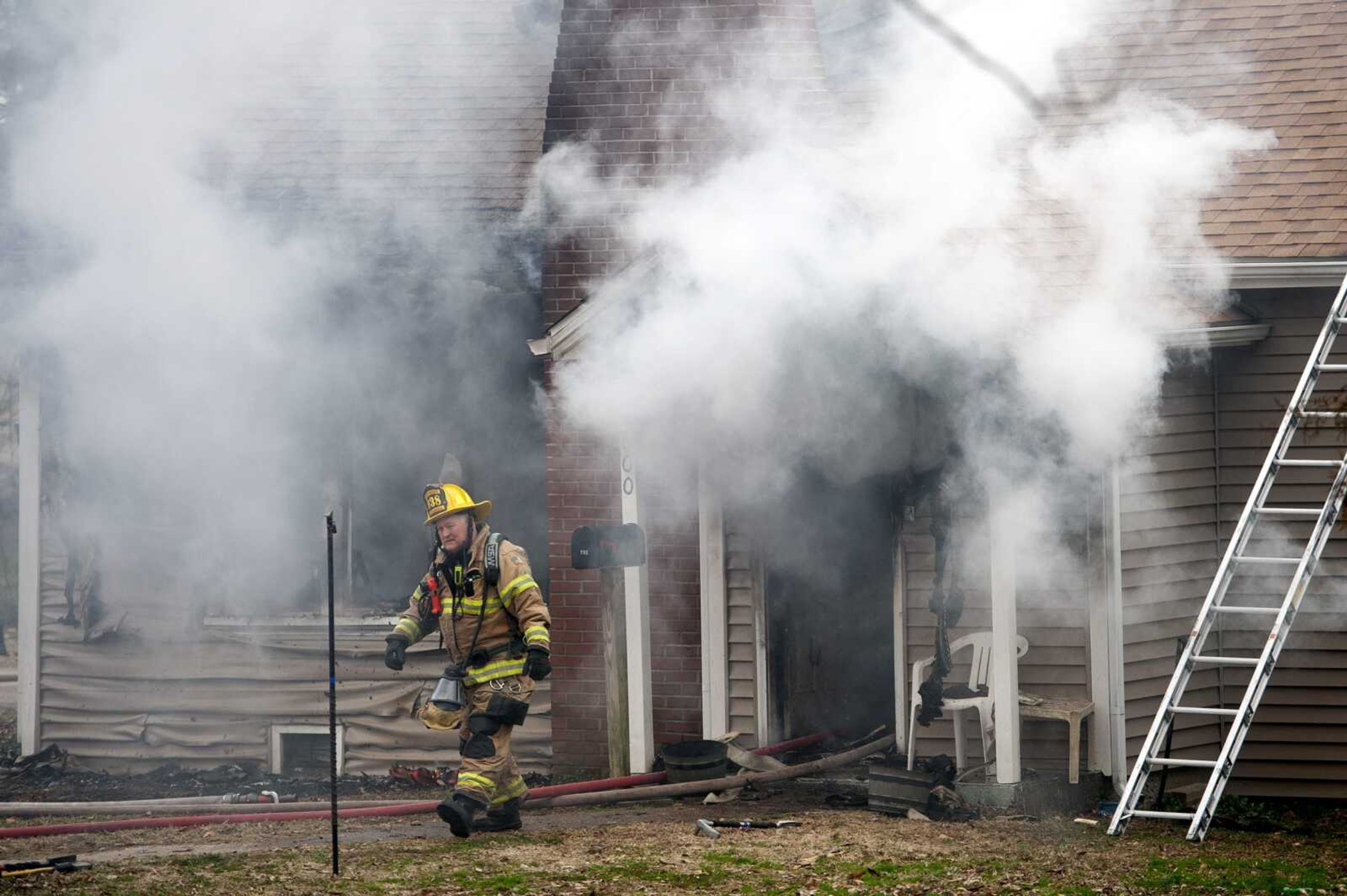 Cape Girardeau firefighter Larry Hagan tends to a house fire with other members of the Cape Girardeau Fire Department on Friday at 600 S. Louis St. in Cape Girardeau.